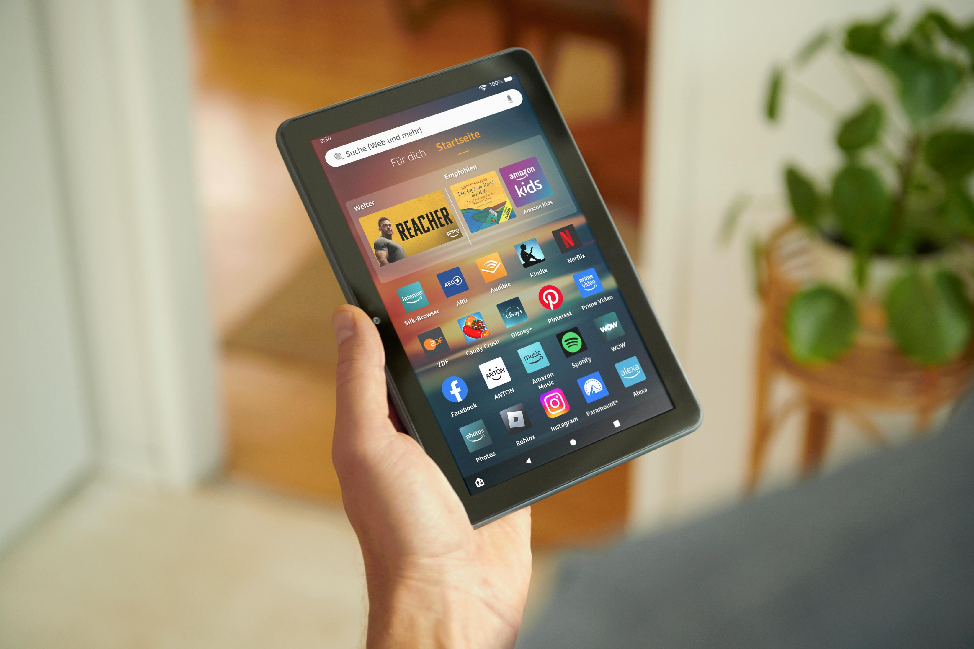 Tablet in der Hand, zeigt App-Oberfläche. Innenraum mit Pflanze sichtbar.