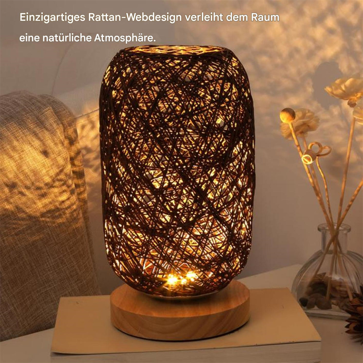 Eine gewebte Rattanlampe mit Holzsockel, auf einem Tisch. Im Hintergrund Dekorationen.