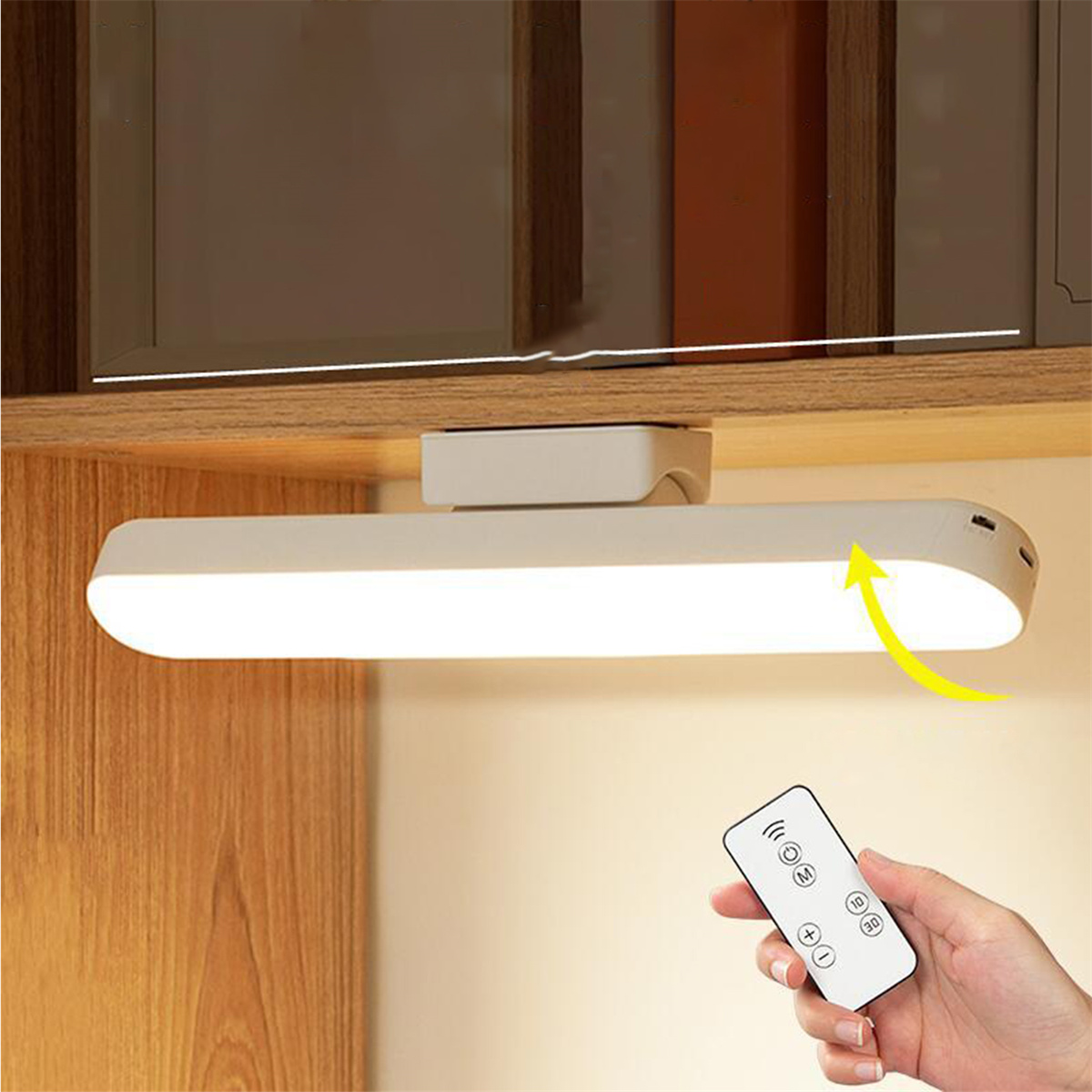 Eine weiße Lichtleiste unter einem Schrank installiert, mit einer Fernbedienung in der Hand.