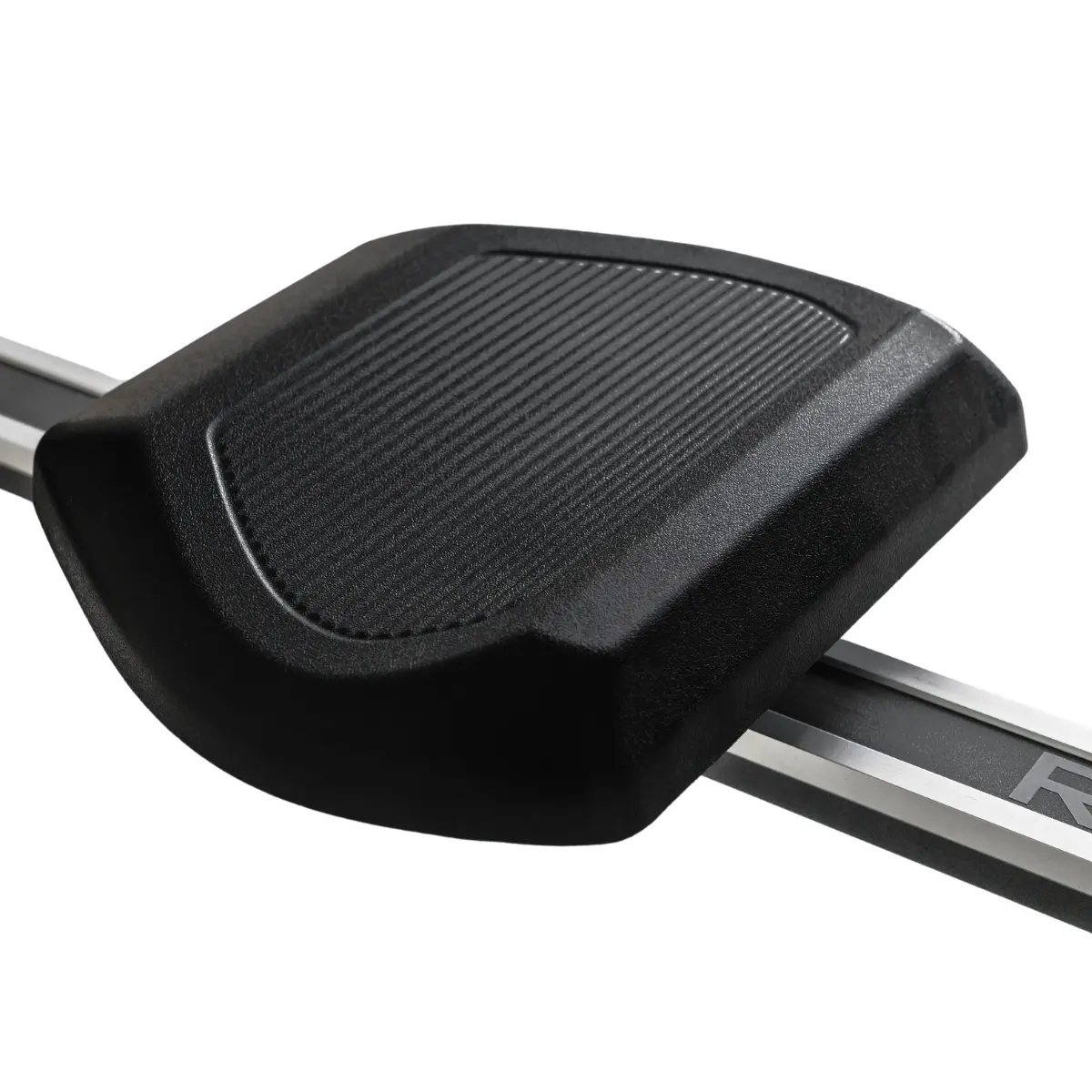 Black Rowing machine seat with textured surface, on a silver rail.