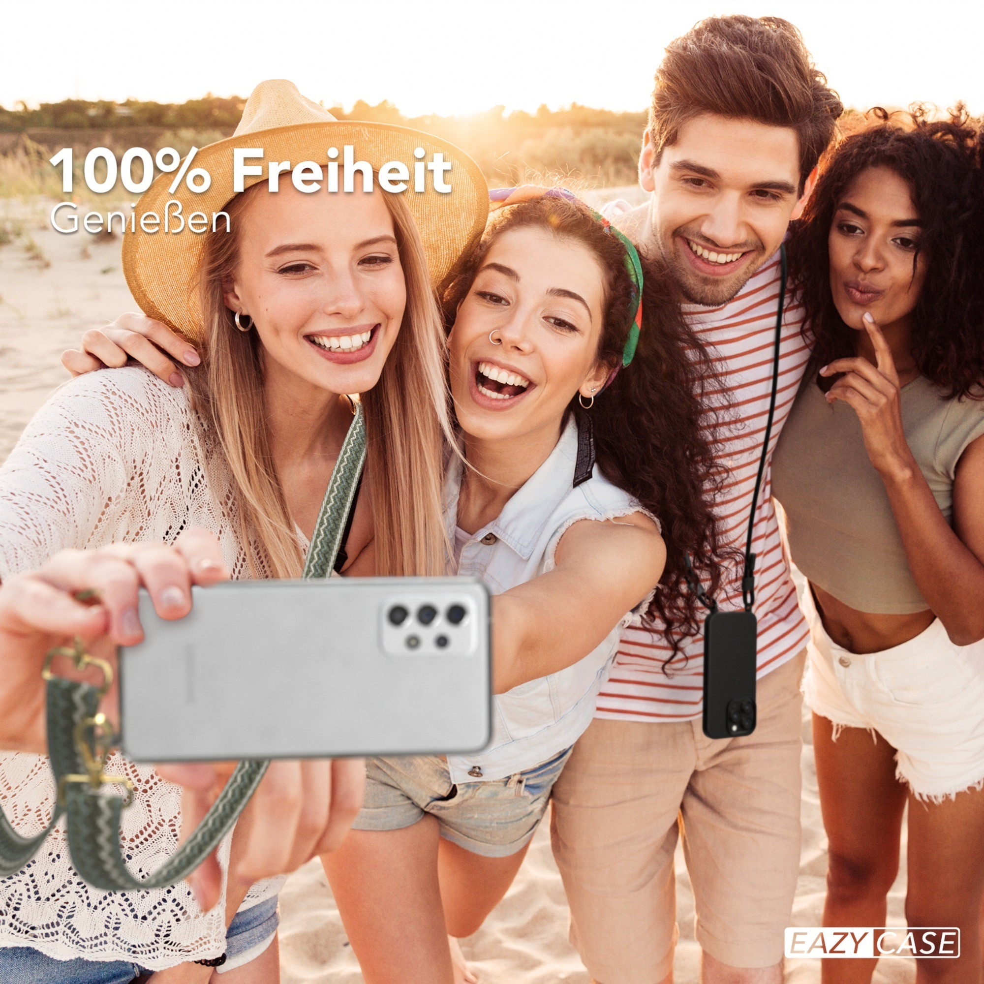 Vier Personen machen ein Selfie am Strand. Drei lächeln und einer zeigt.