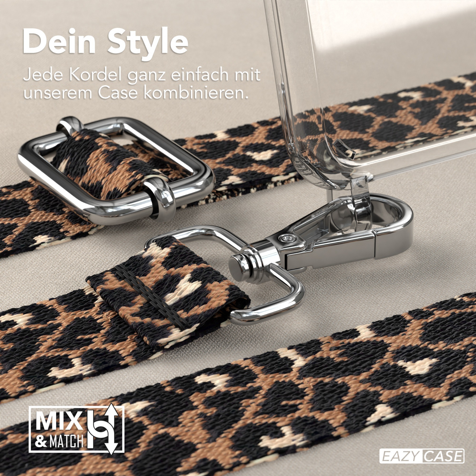 Nahaufnahme eines Handystraps mit Leopardenmuster und Metallverschlüssen. Hintergrund ist eine hellbraune Oberfläche.