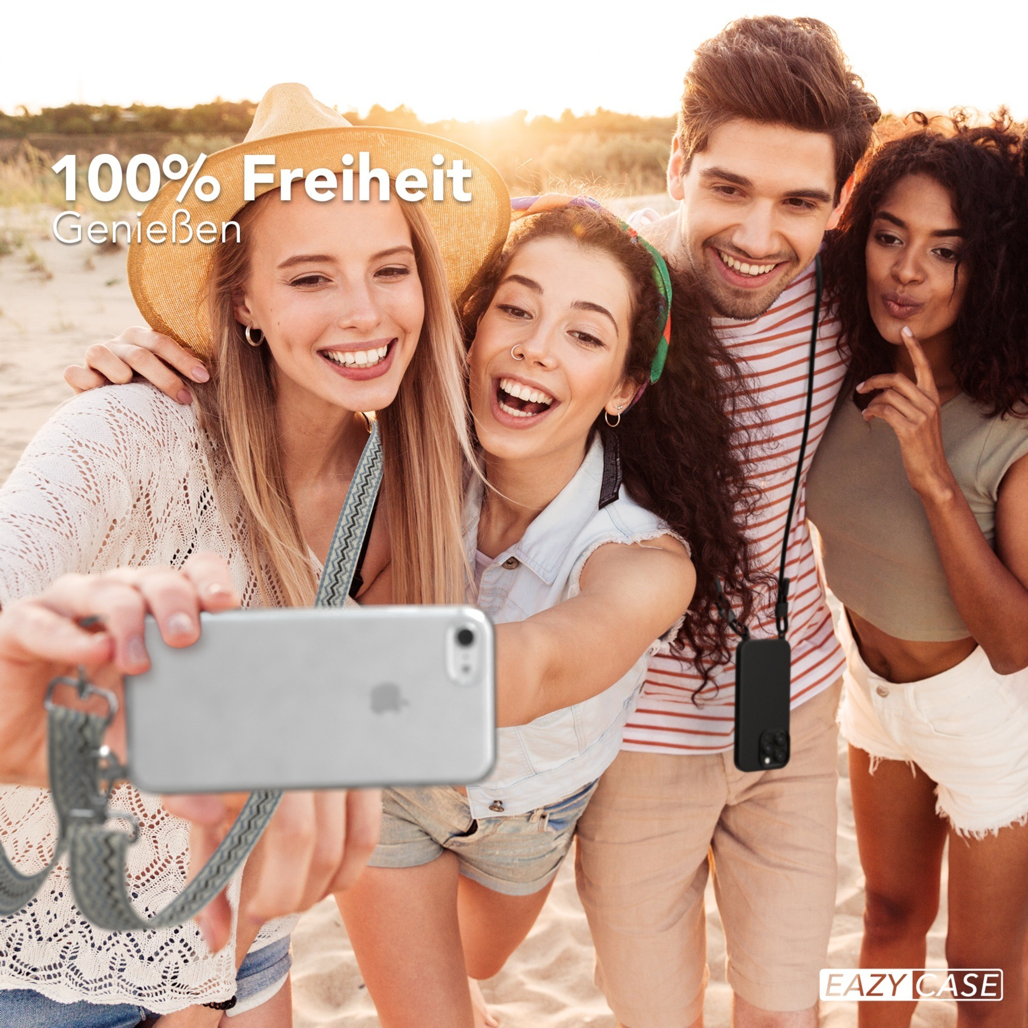 Vier Personen machen ein Selfie mit einem Telefon an der Leine, lächelnd am Strand.