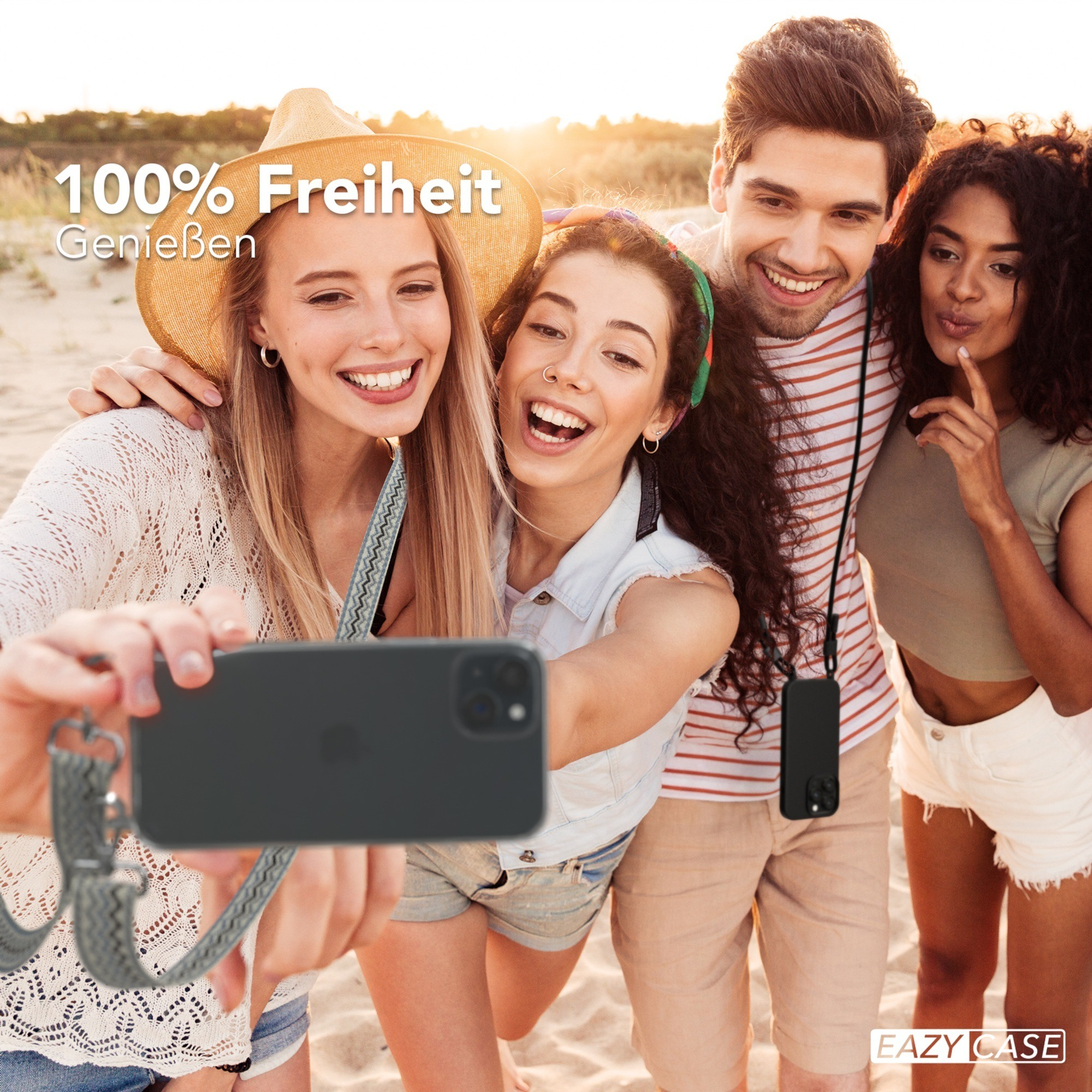 Vier Personen machen ein Selfie mit einem Handy. Sie sind am Strand, lächeln und lachen.