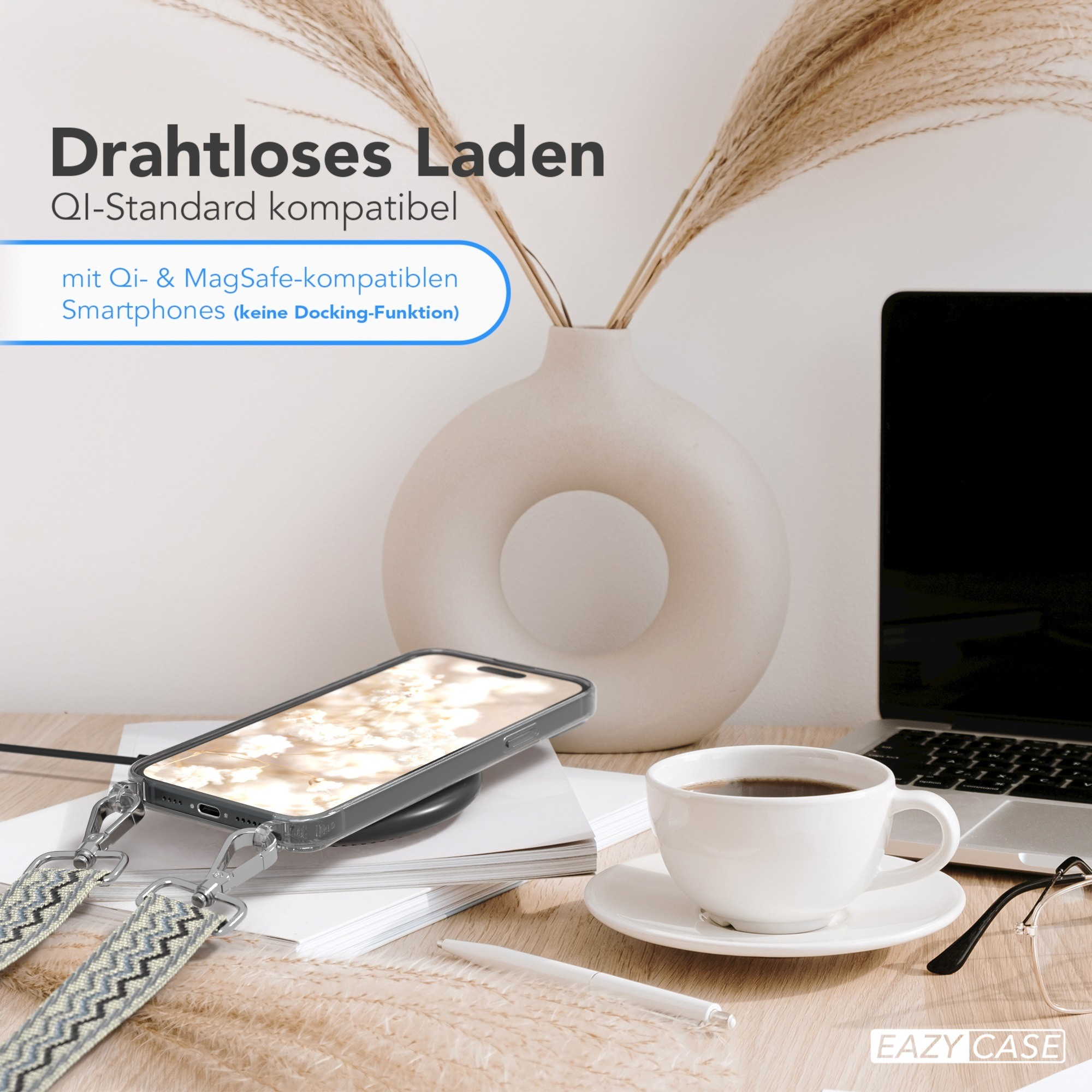Telefon auf kabellosem Ladegerät, Kaffeetasse, Vase mit Pflanzen auf dem Schreibtisch.