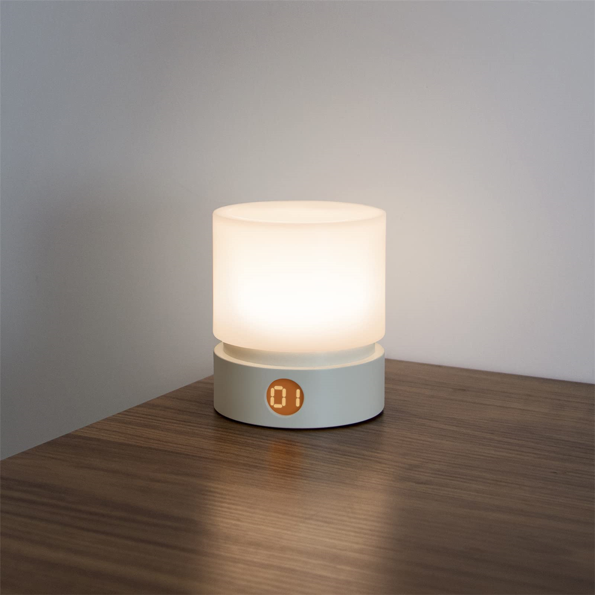Weiß-graue Nachttischlampe, zylindrisch, mit Digitalanzeige, die die Uhrzeit anzeigt.