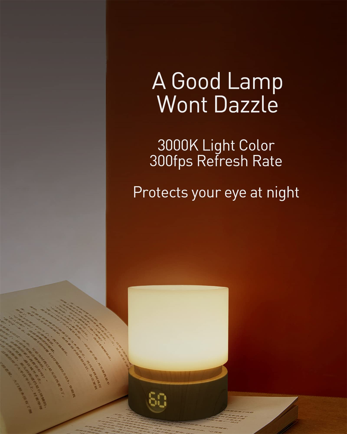 Eine Lampe mit Holzsockel steht auf einem Tisch, im Hintergrund ein Buch und eine rote Wand.