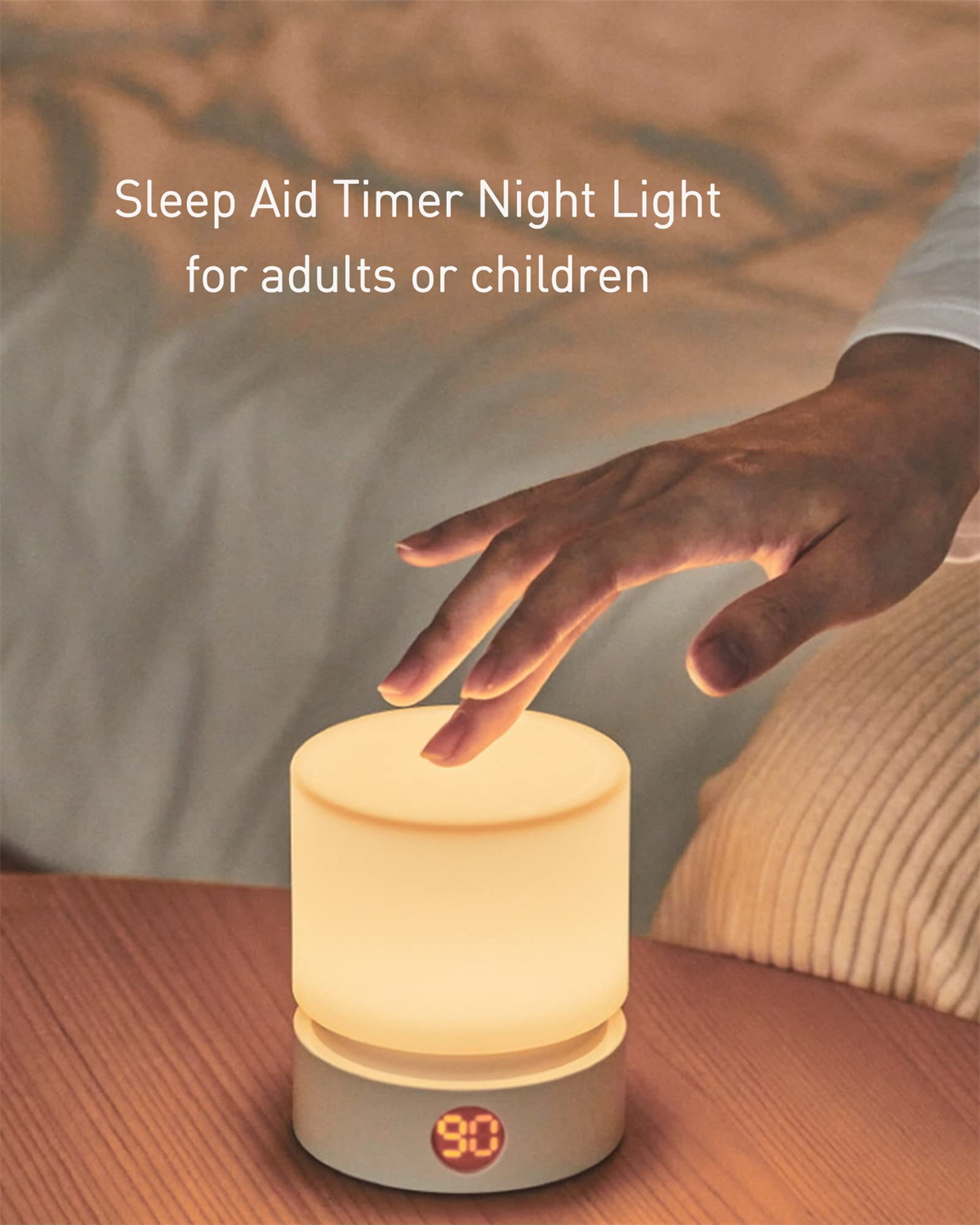 Ein Nachtlicht leuchtet auf einem Tisch. Eine Hand greift danach. Hintergrund: ein Bett.