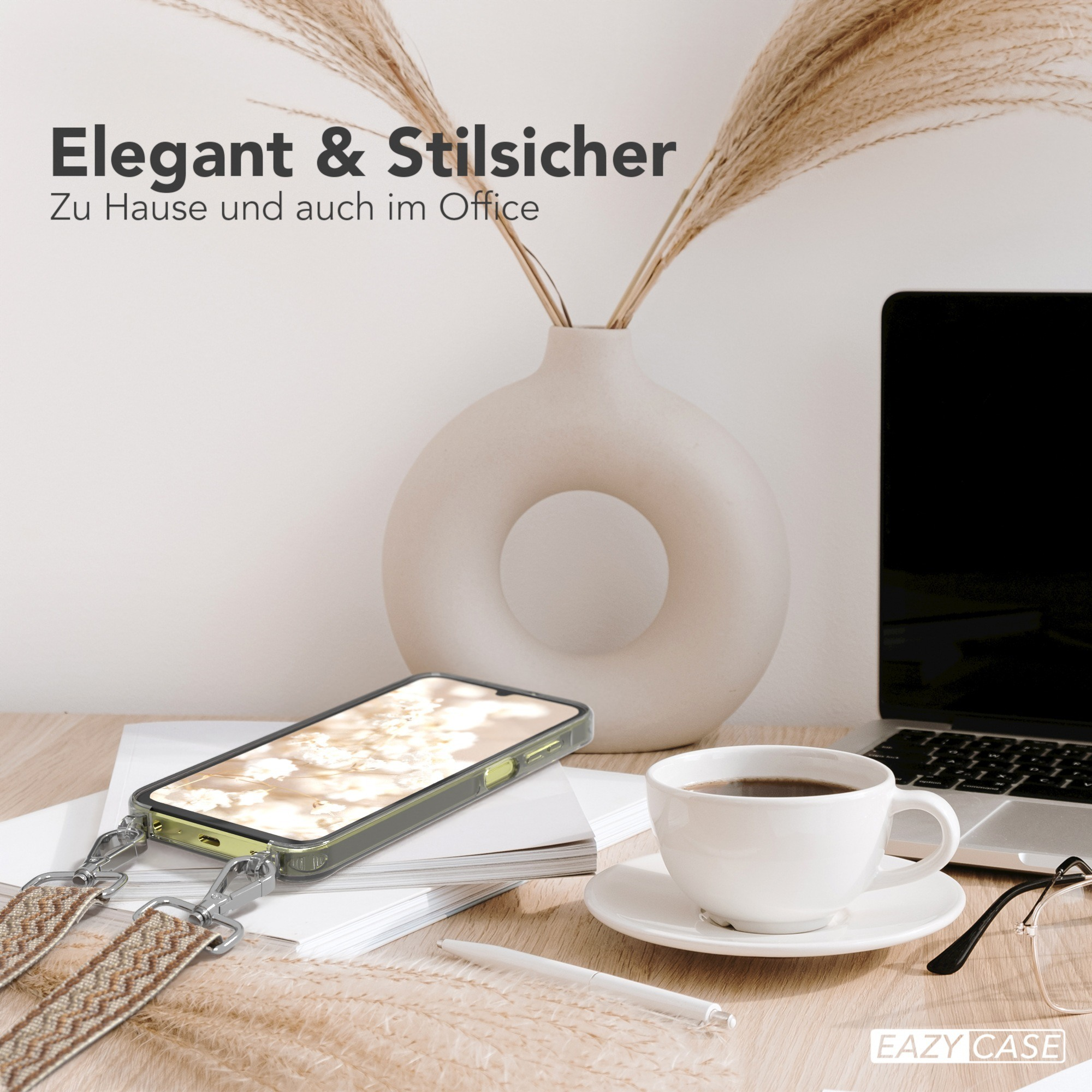 Ein Telefon in einer transparenten Hülle liegt auf einem Schreibtisch mit Kaffeetasse und Blumen.