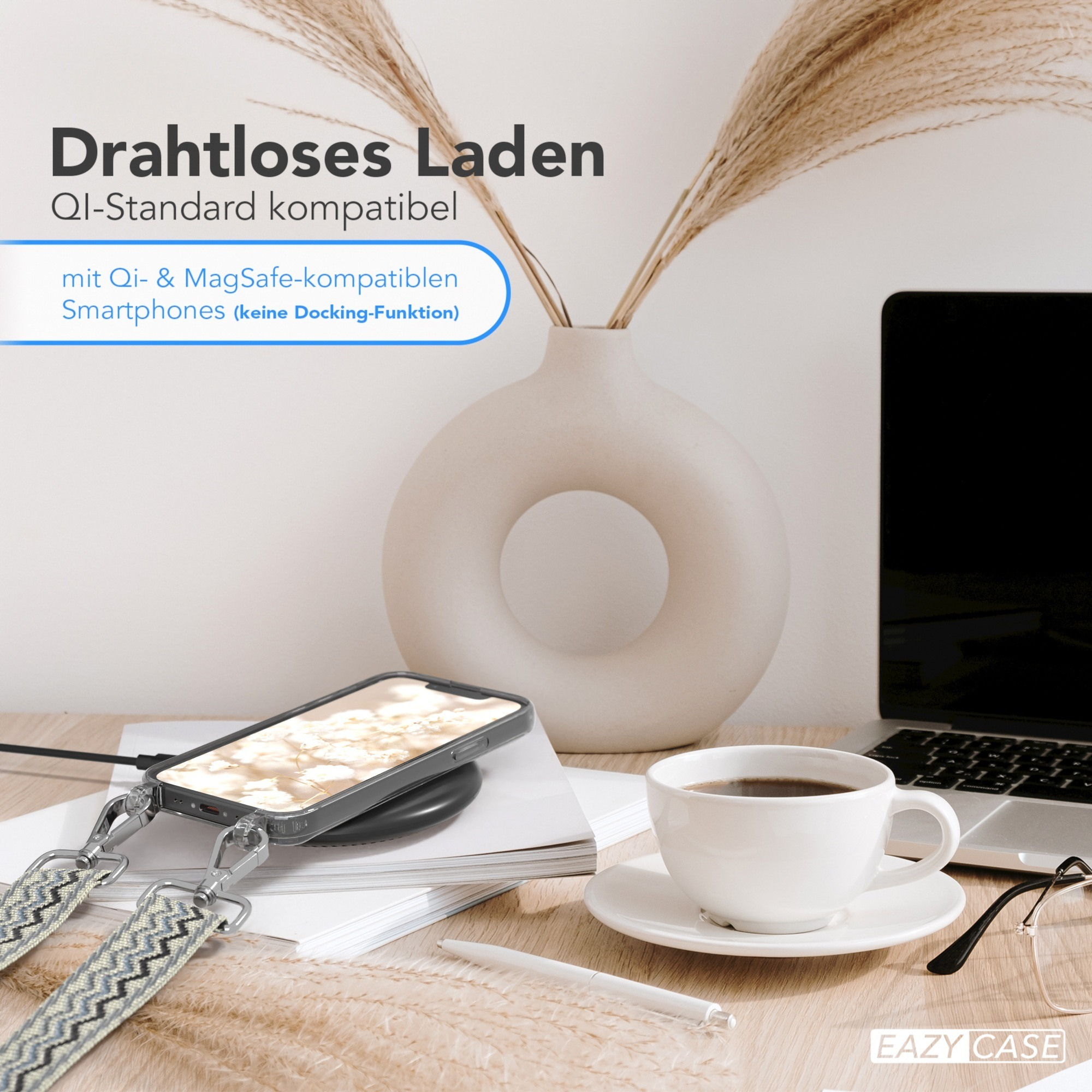 Telefon auf kabellosem Ladegerät mit Kaffeetasse, Blumen und Laptop im Hintergrund.