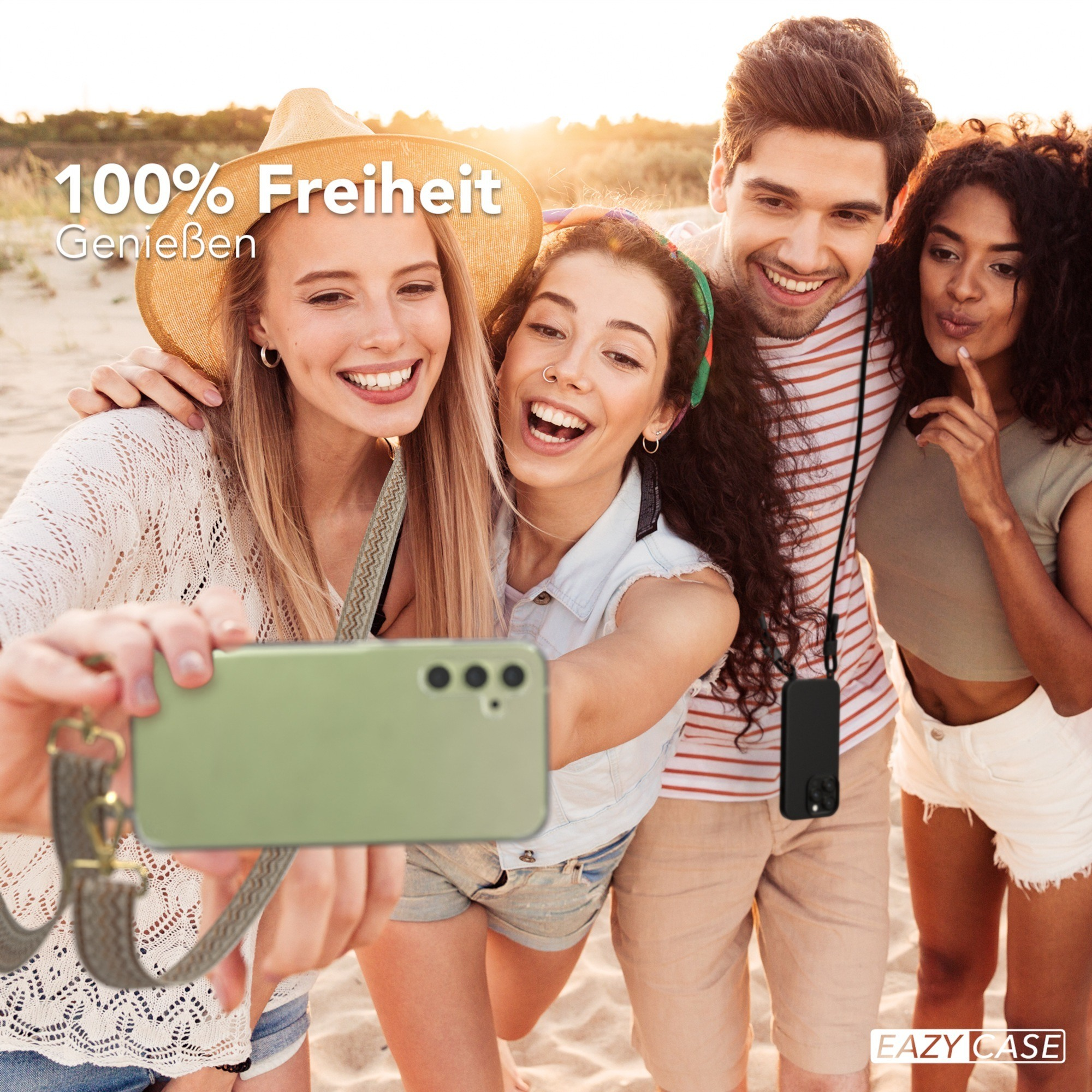 Vier Personen machen ein Selfie am Strand. Ein Telefon mit Hülle ist im Vordergrund.