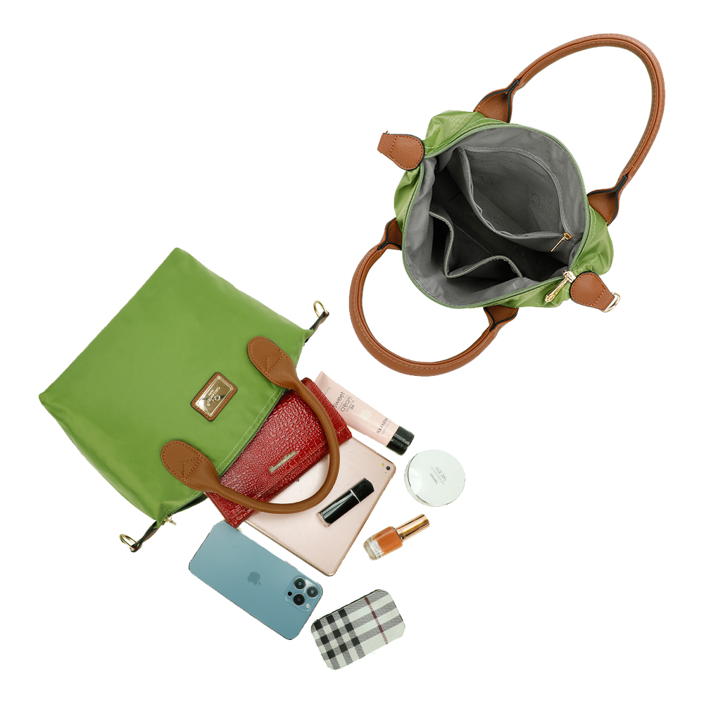 Bolso verde con objetos derramándose. Cartera roja, teléfono, maquillaje y otros objetos dispersos.