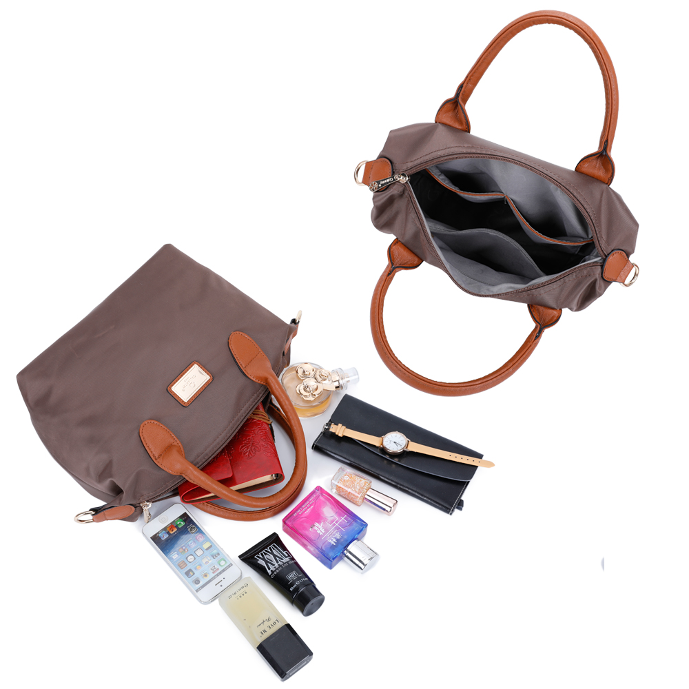 Zwei Handtaschen, eine geöffnet mit Inhalt, und Accessoires auf dem Tisch.