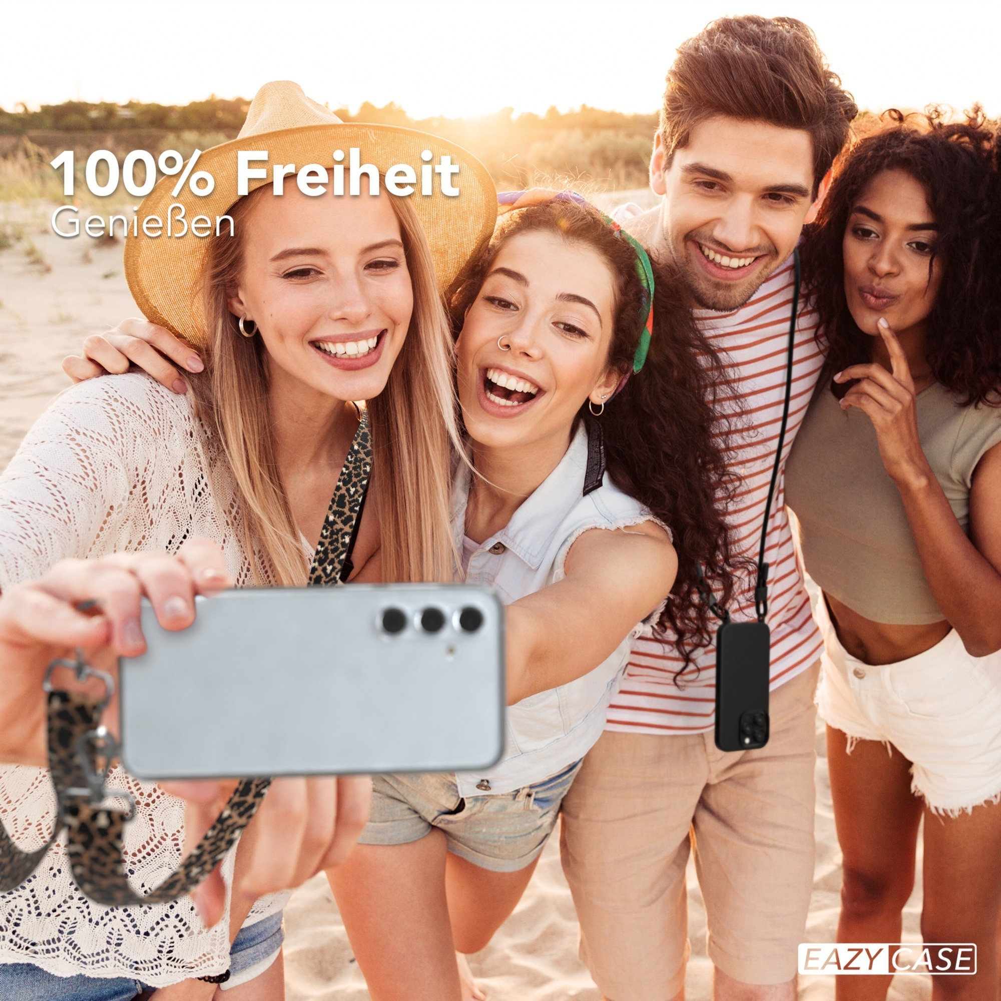 Vier Personen lächeln, machen Selfie am Strand. Einer hält Telefon mit Riemen. Text: 100% Freiheit Geniessen.