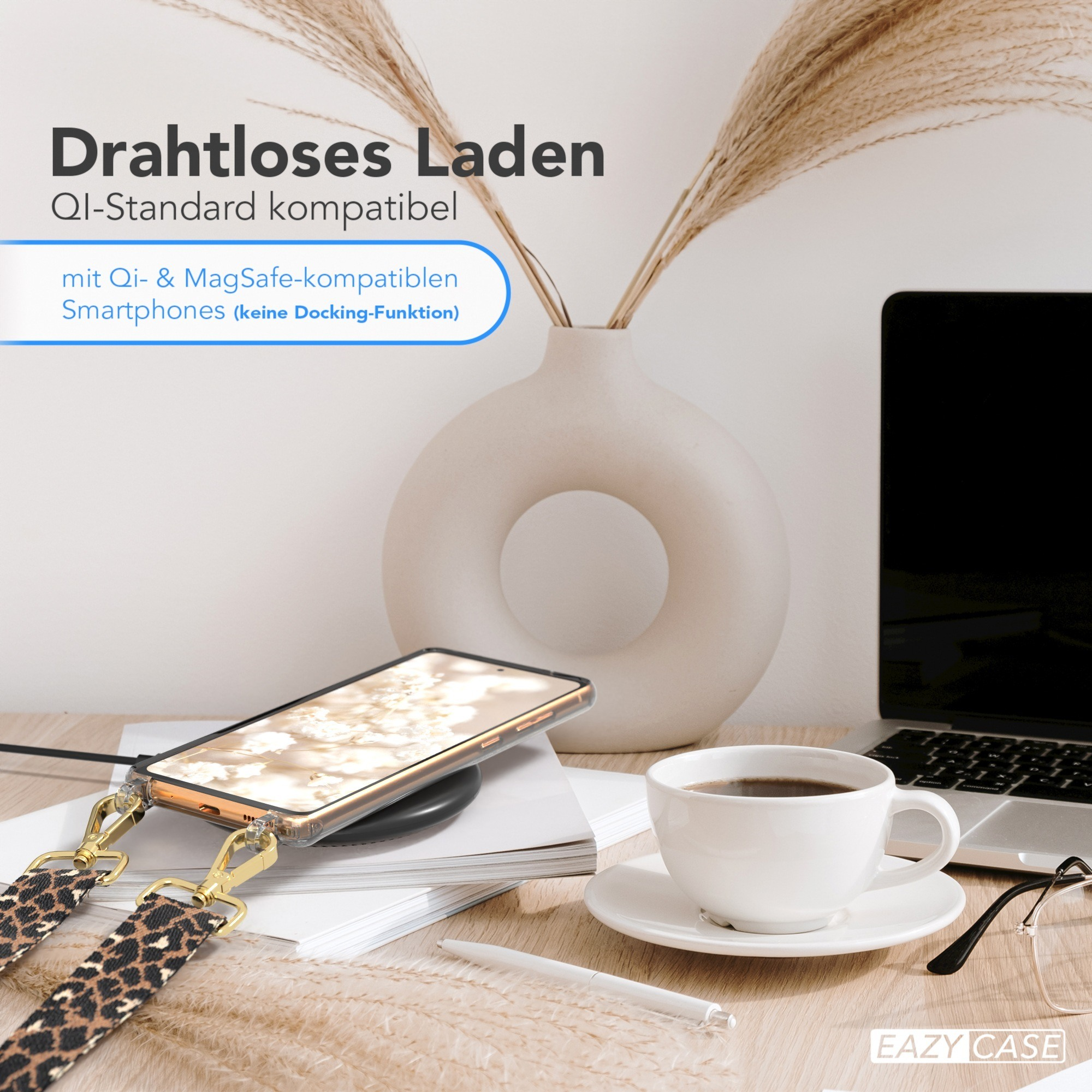 Ein Telefon auf einem kabellosen Ladegerät. Eine Tasse Kaffee und ein Laptop stehen auf einem Schreibtisch.