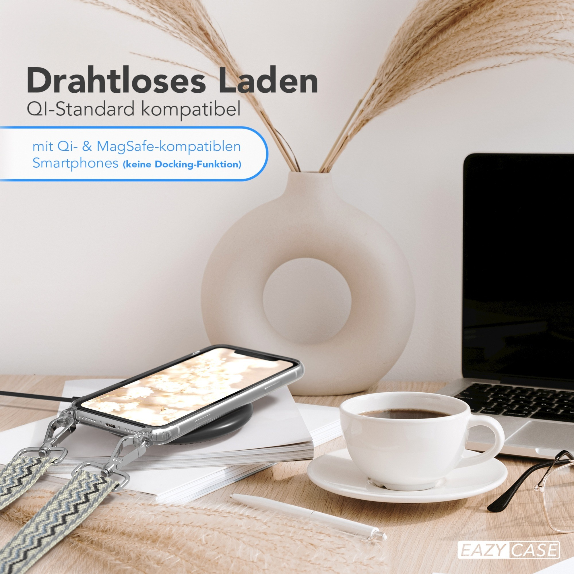 Ein Telefon liegt auf einem kabellosen Ladegerät auf einem Schreibtisch. Es gibt eine Tasse Kaffee, einen Laptop und eine Vase.
