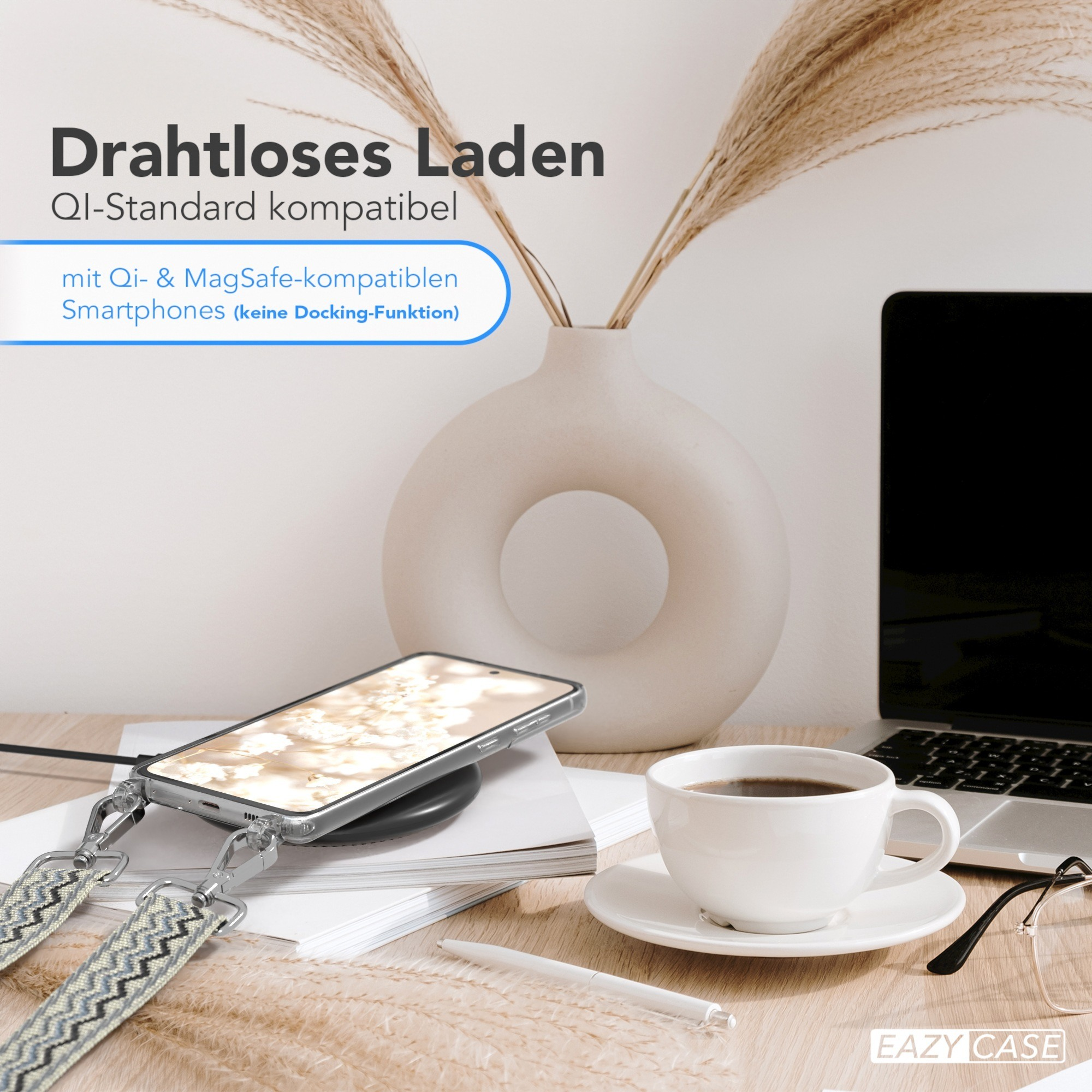 Ein Telefon mit Hülle wird drahtlos auf einem Schreibtisch aufgeladen. Es gibt eine Kaffeetasse und eine Vase mit Pflanzen.