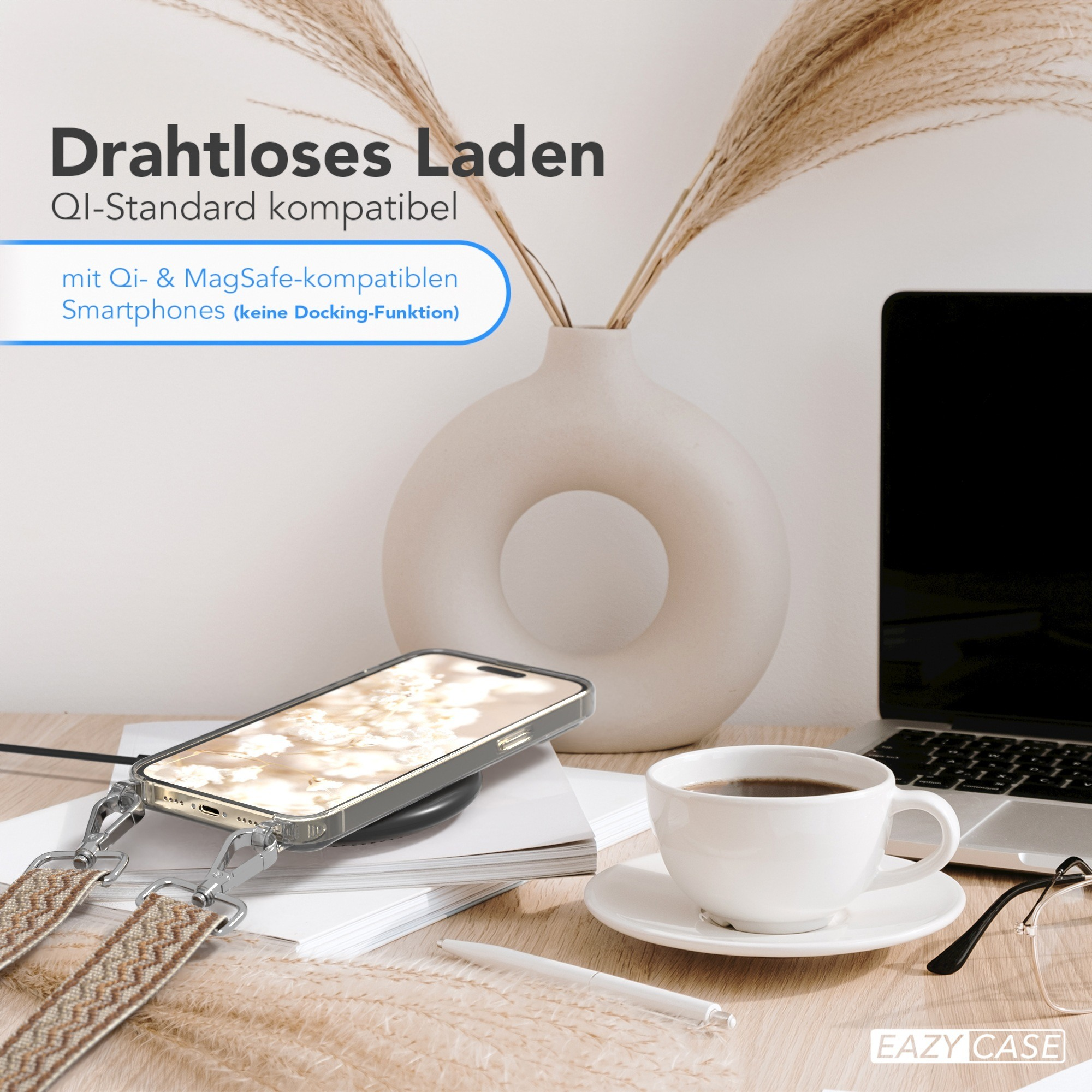 Telefon auf kabellosem Ladegerät neben einer Tasse Kaffee, Stift und Blumenvase.