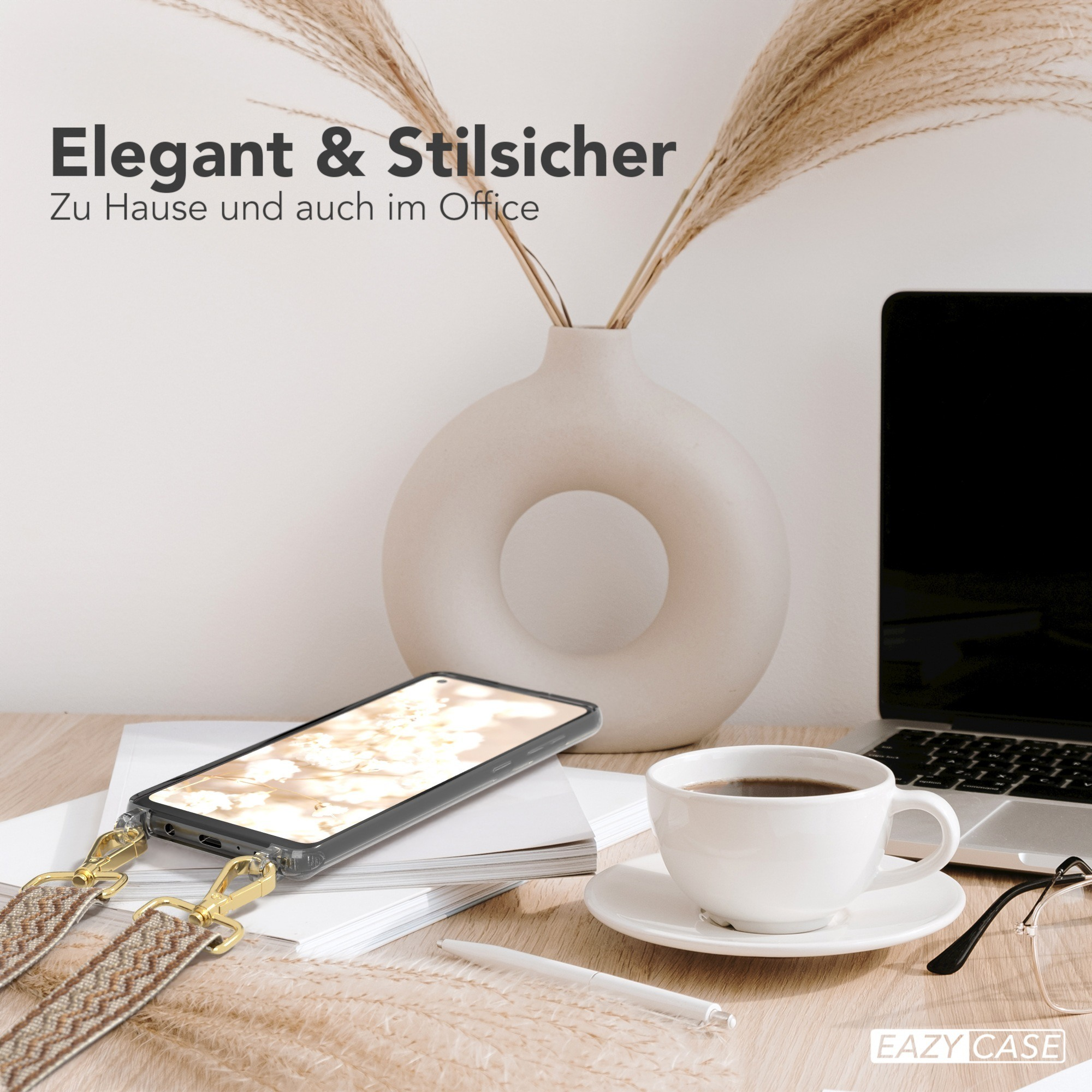 Ein Telefon auf einem Schreibtisch mit Kaffeetasse, Laptop und einer dekorativen Vase mit Pflanzen.