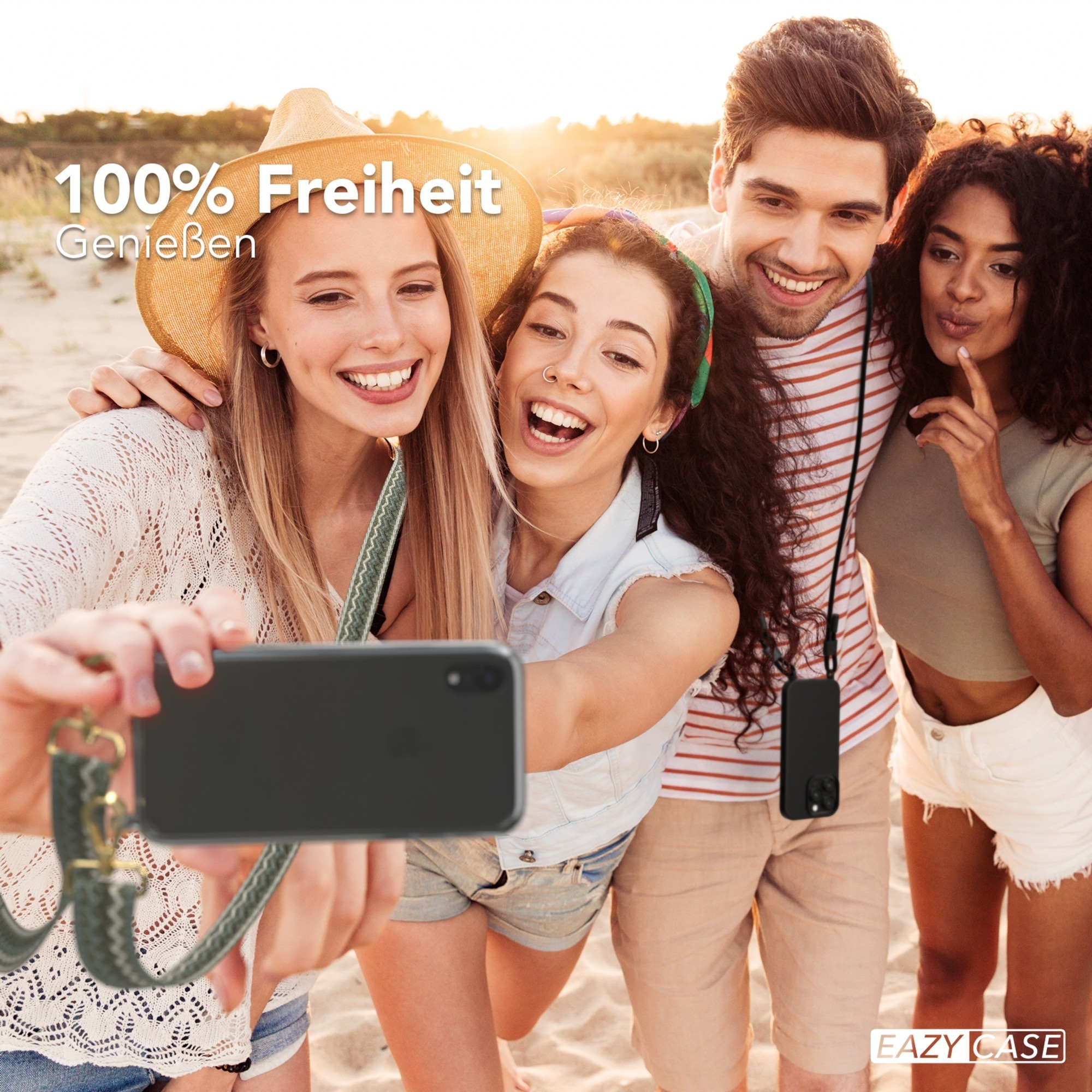 Vier lächelnde Personen machen ein Selfie mit einem Telefon mit grünem Riemen am Strand.