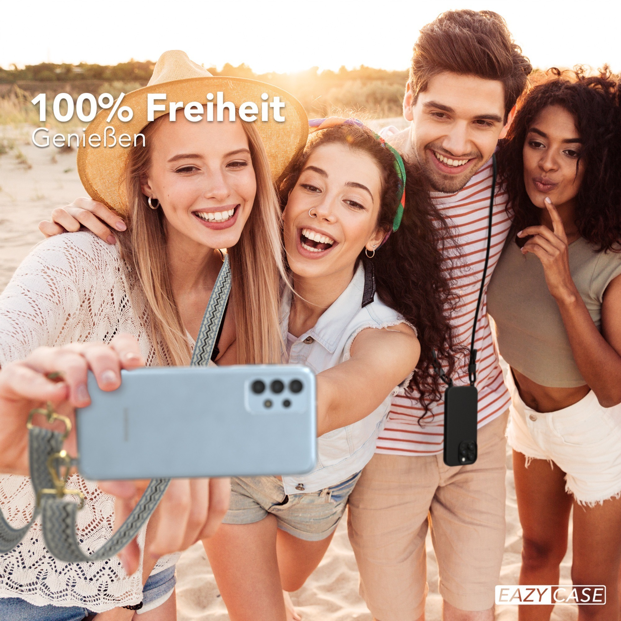Vier lächelnde Personen machen ein Selfie am Strand, halten das Telefon mit einer Handyschlaufe.