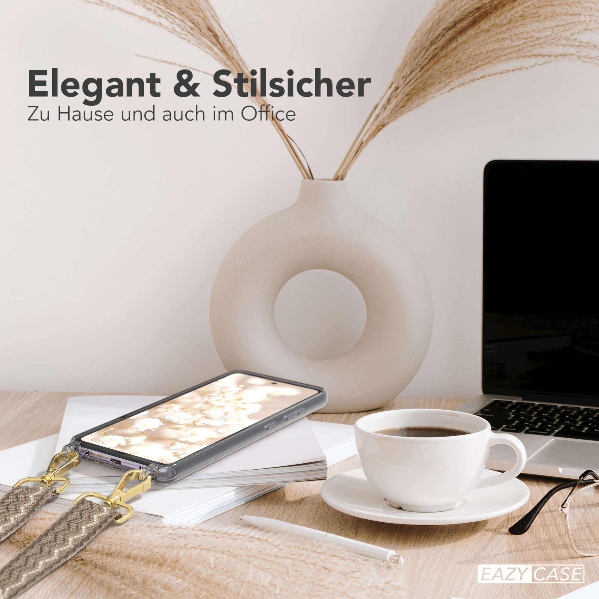 Ein Telefon mit einem Gurt auf einem Schreibtisch, mit Blumen und Kaffee.