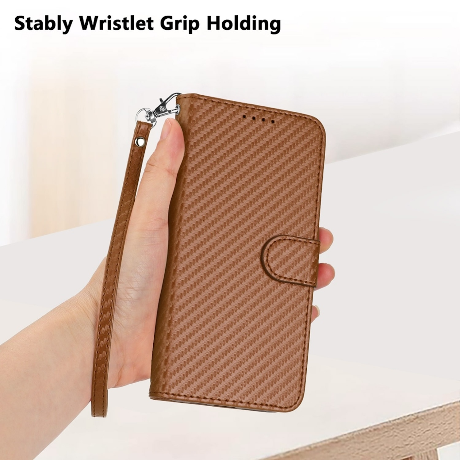 Hand hält eine braune Leder-Handyhülle mit Handgelenksschlaufe. Text: Stabile Handgelenksschlaufe.