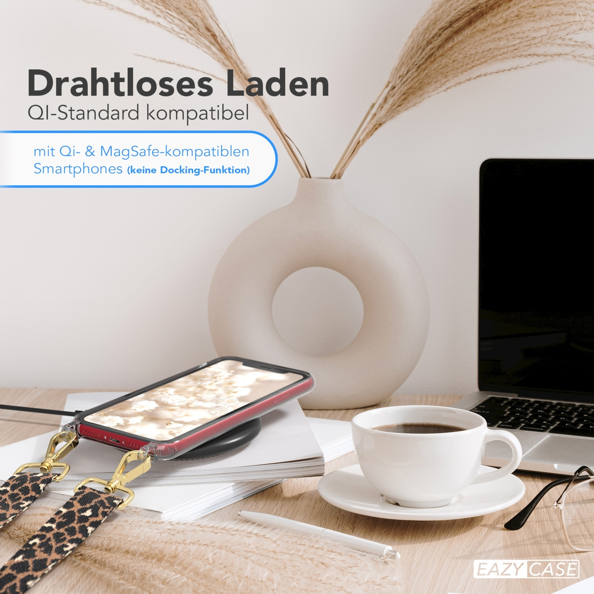 Ein Telefon auf einem kabellosen Ladegerät mit einer Kaffeetasse und einem Laptop im Hintergrund.