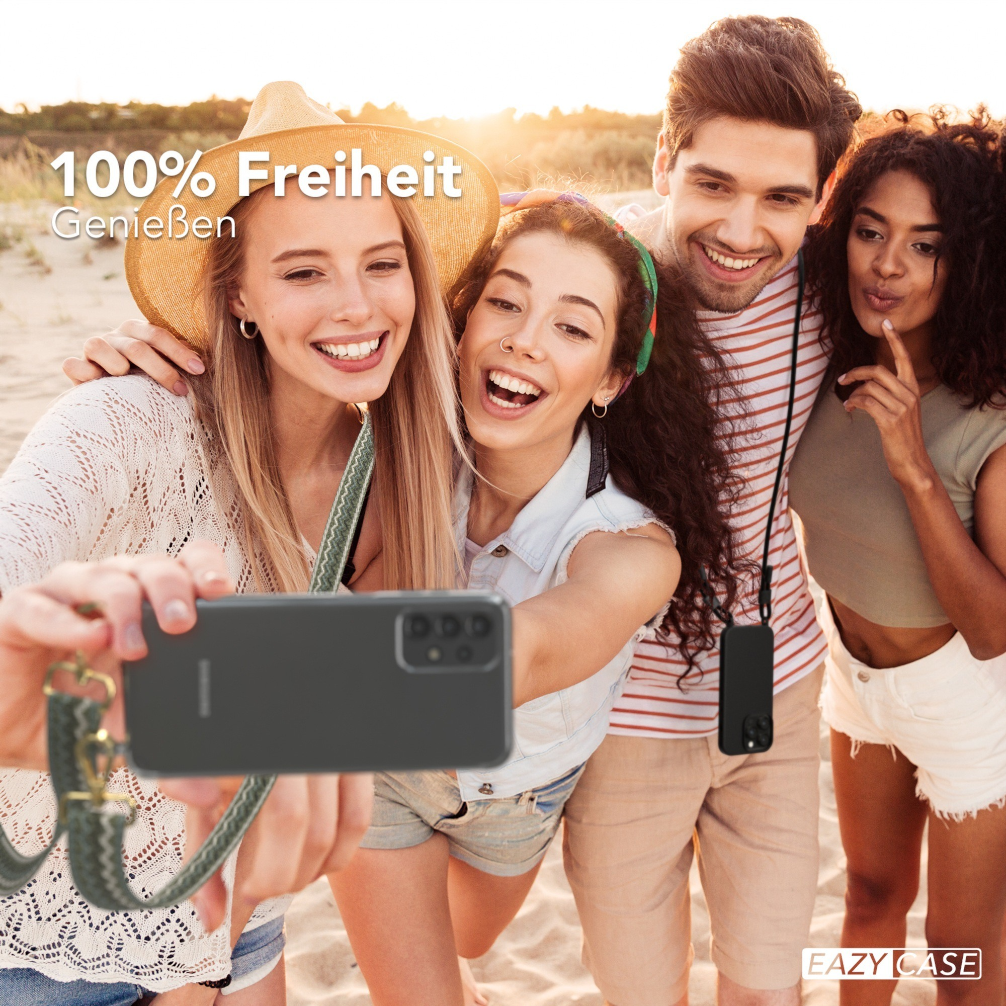 Vier Personen machen ein Selfie am Strand. Einer hält das Telefon mit dem Gurt.