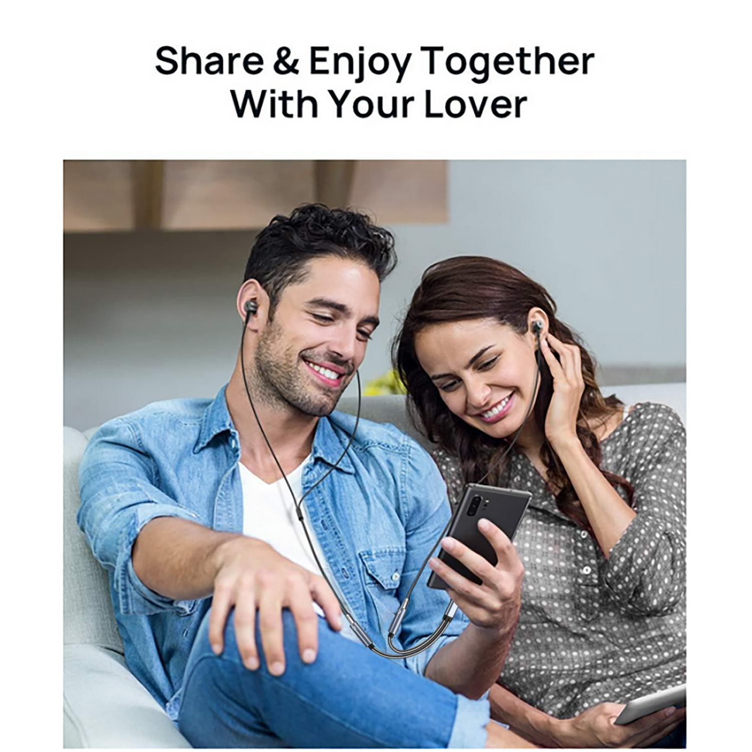 A couple shares earphones, looking at a phone with a shared audio cable.