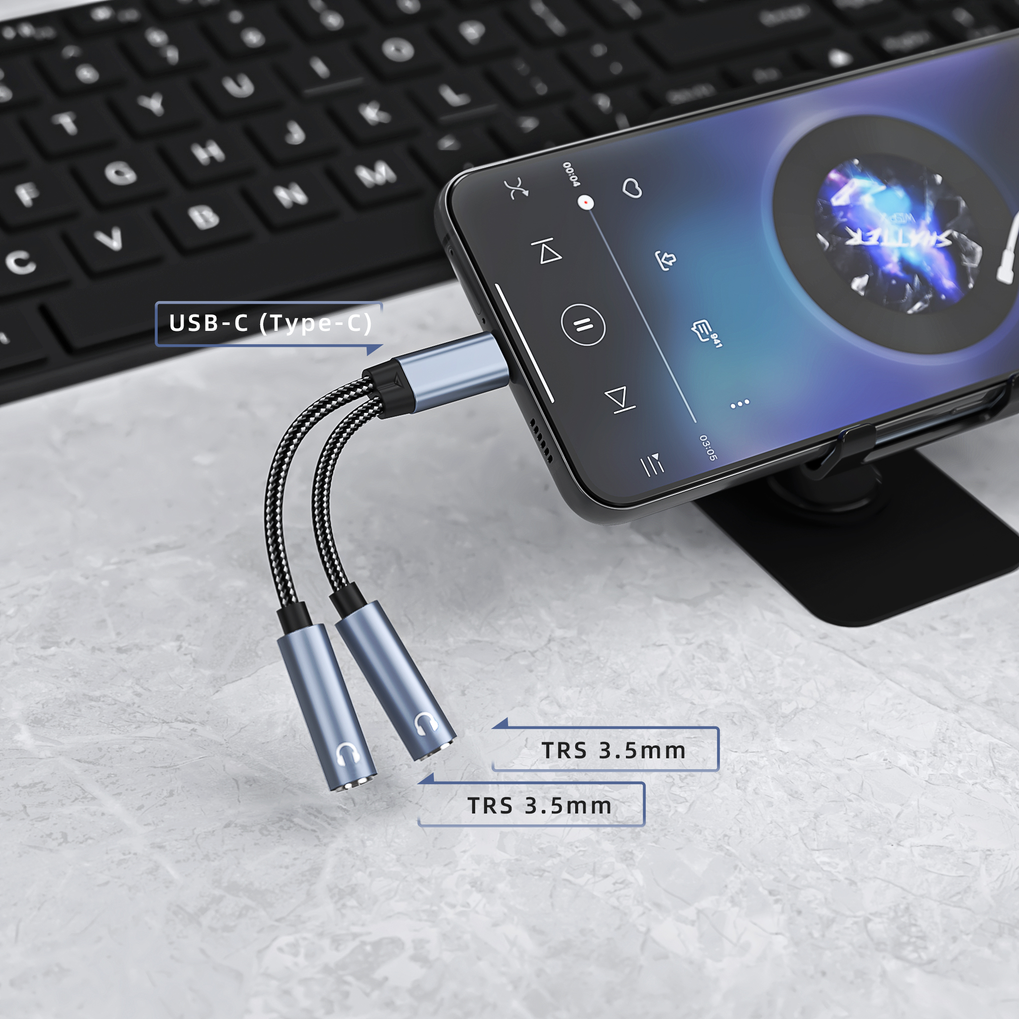 A USB-C to dual 3.5mm adapter is plugged into a phone. The adapter has two 3.5mm ports.