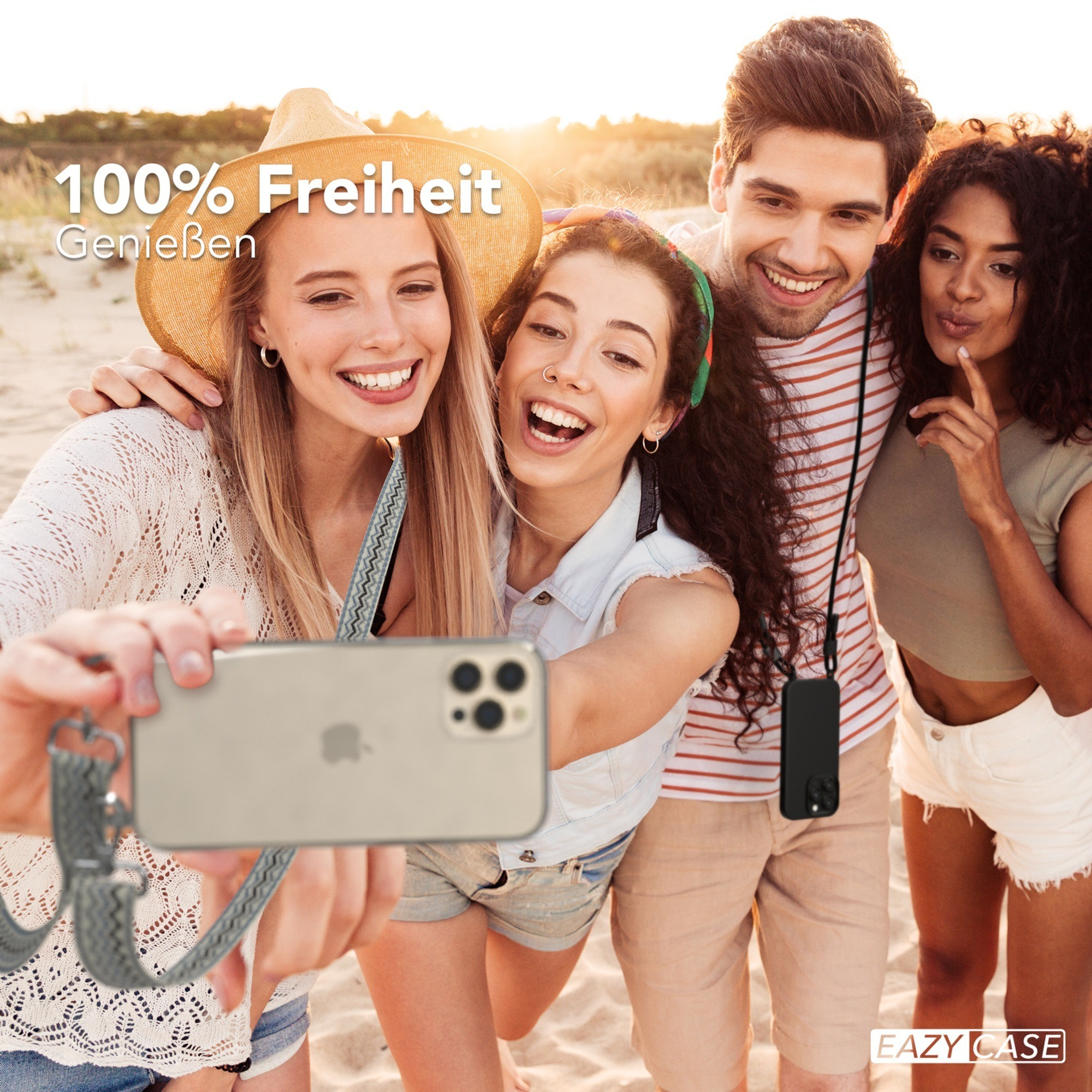 Vier Personen lächeln und machen ein Selfie am Strand, halten ein Telefon mit Hülle und Gurt.