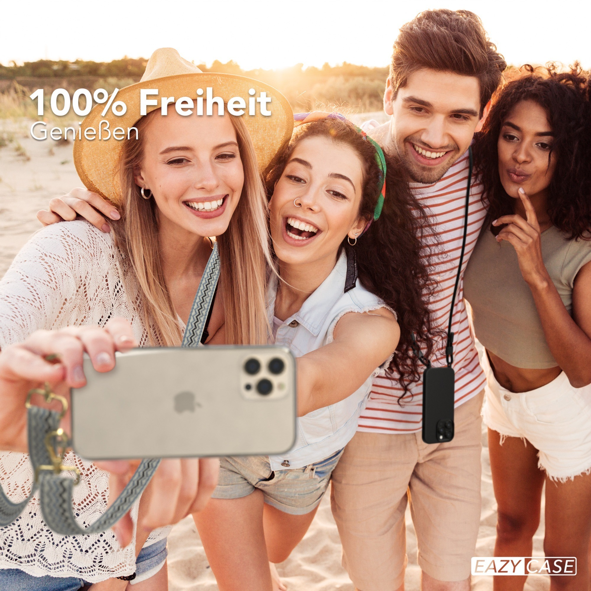 Vier Freunde machen ein Selfie am Strand, lächelnd.