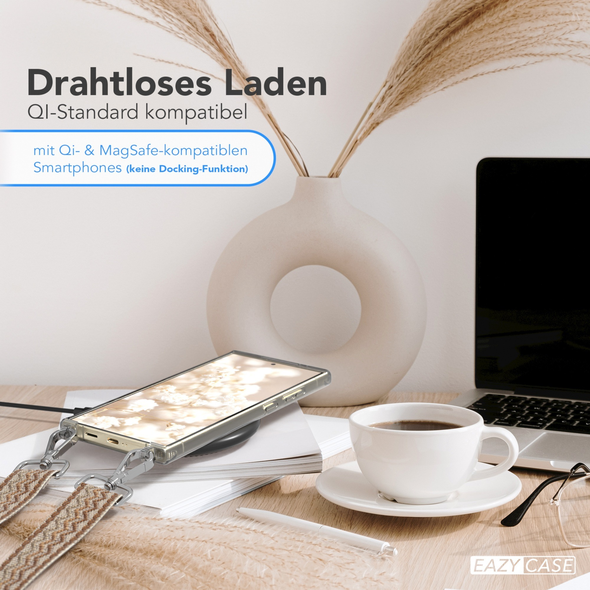 Ein Telefon auf einem kabellosen Ladegerät. Kaffeetasse, Stift und Laptop auf einem Schreibtisch. Hintergrund: Blumen.