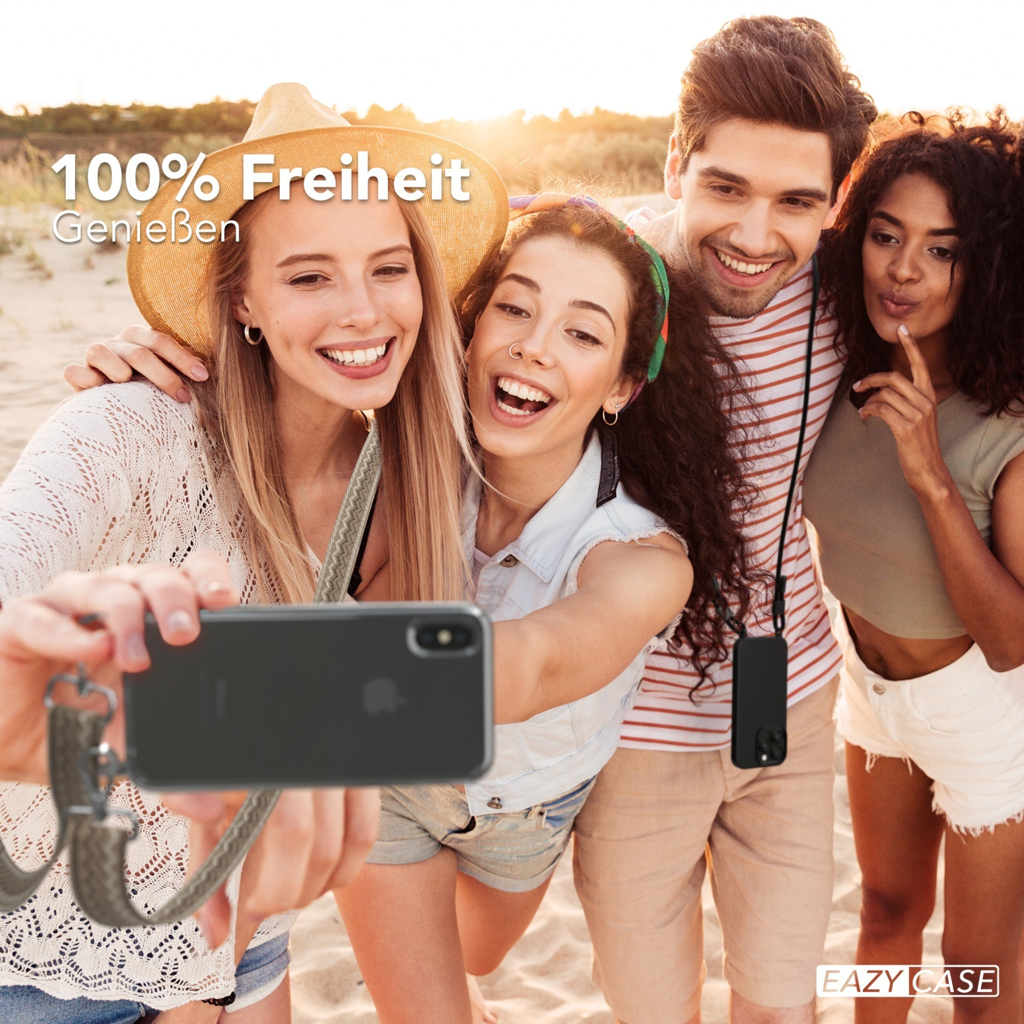 Vier junge Leute machen ein Selfie am Strand, einer hält das Telefon mit einem Riemen.