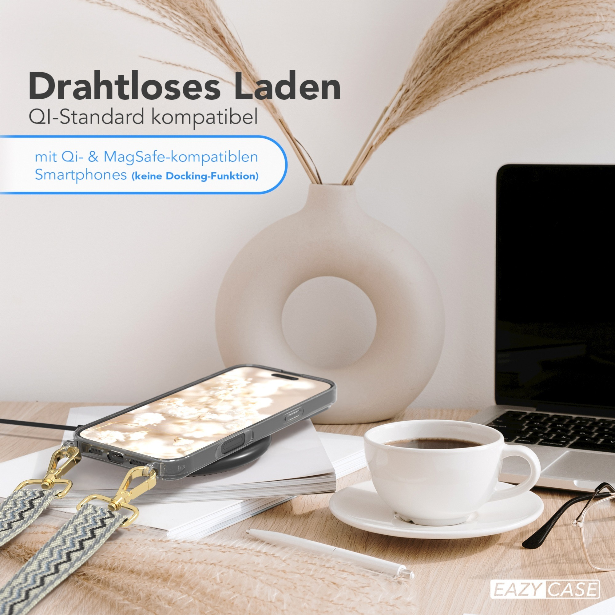 Ein Telefon auf einem kabellosen Ladegerät, Kaffee, Laptop und eine Vase mit Pflanzen auf einem Holztisch.