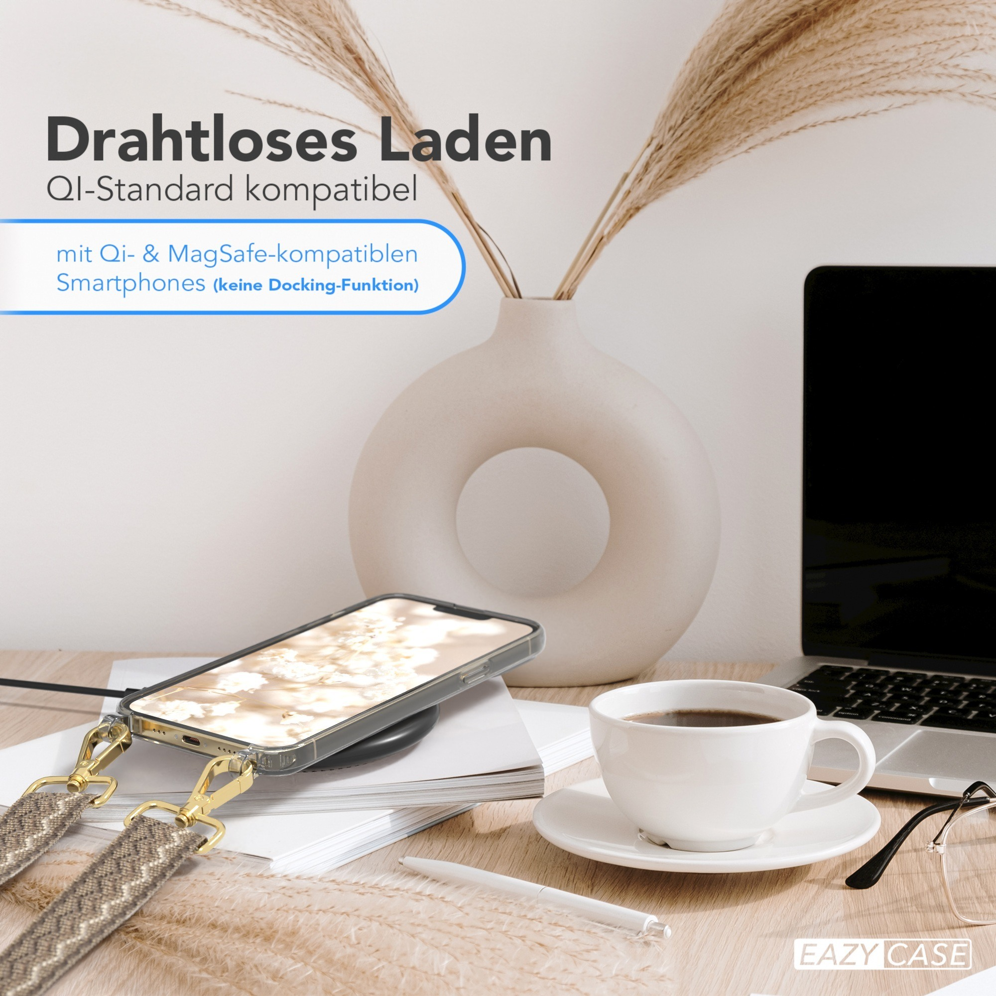 Ein Telefon lädt kabellos auf einem Schreibtisch mit Vase und Kaffeetasse.