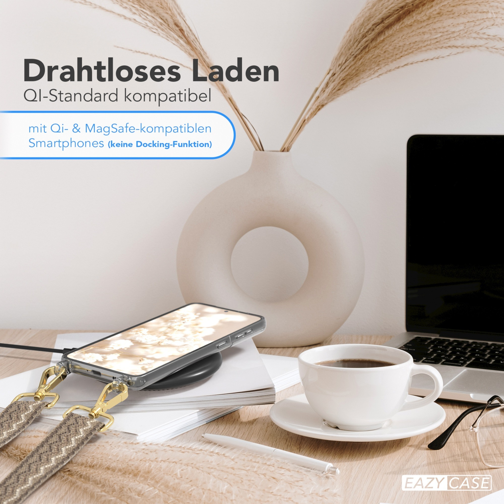 Ein Telefon, das drahtlos auf einem Schreibtisch geladen wird, mit einer Tasse Kaffee und einem Laptop im Hintergrund.