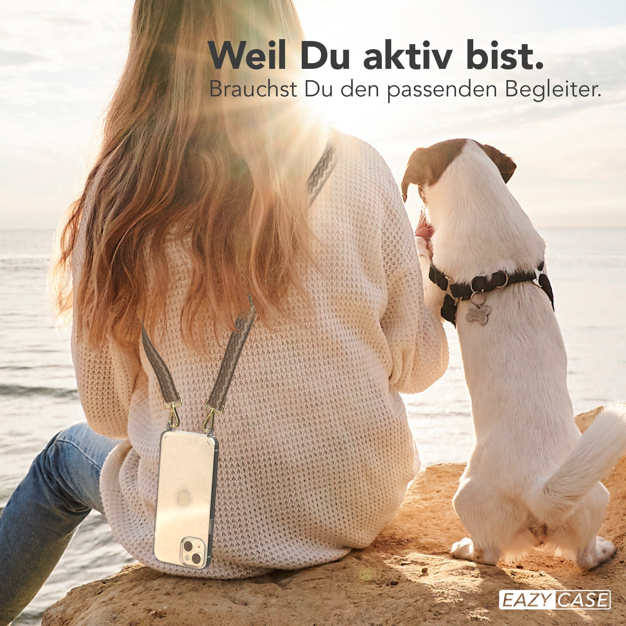 Frau und Hund am Strand. Frau trägt Handyhülle mit klarem Case und braunem Gurt.