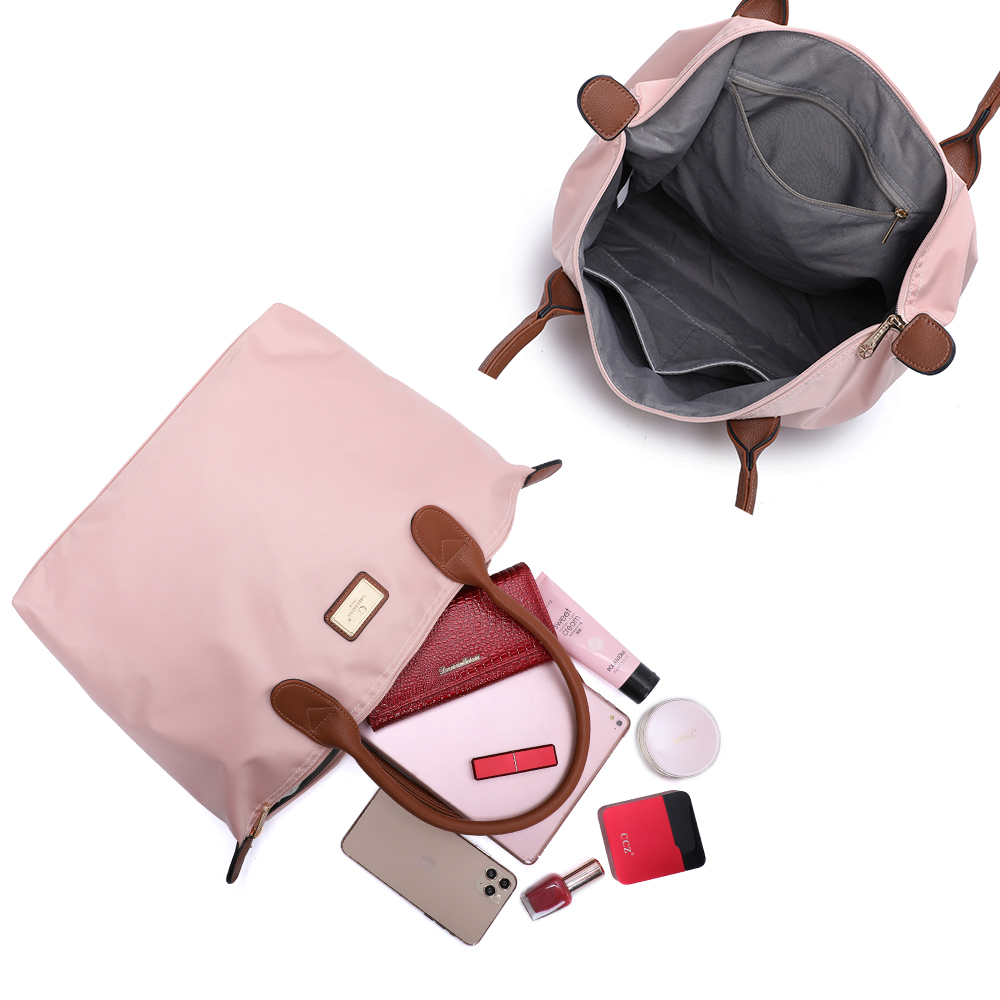 Un bolso rosa con asas marrones está abierto, revelando contenidos como una cartera y un teléfono.