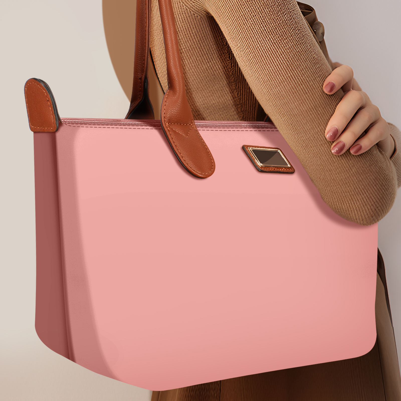 Una bolsa tote rosa con asas marrones es sostenida por una persona que lleva una blusa marrón.