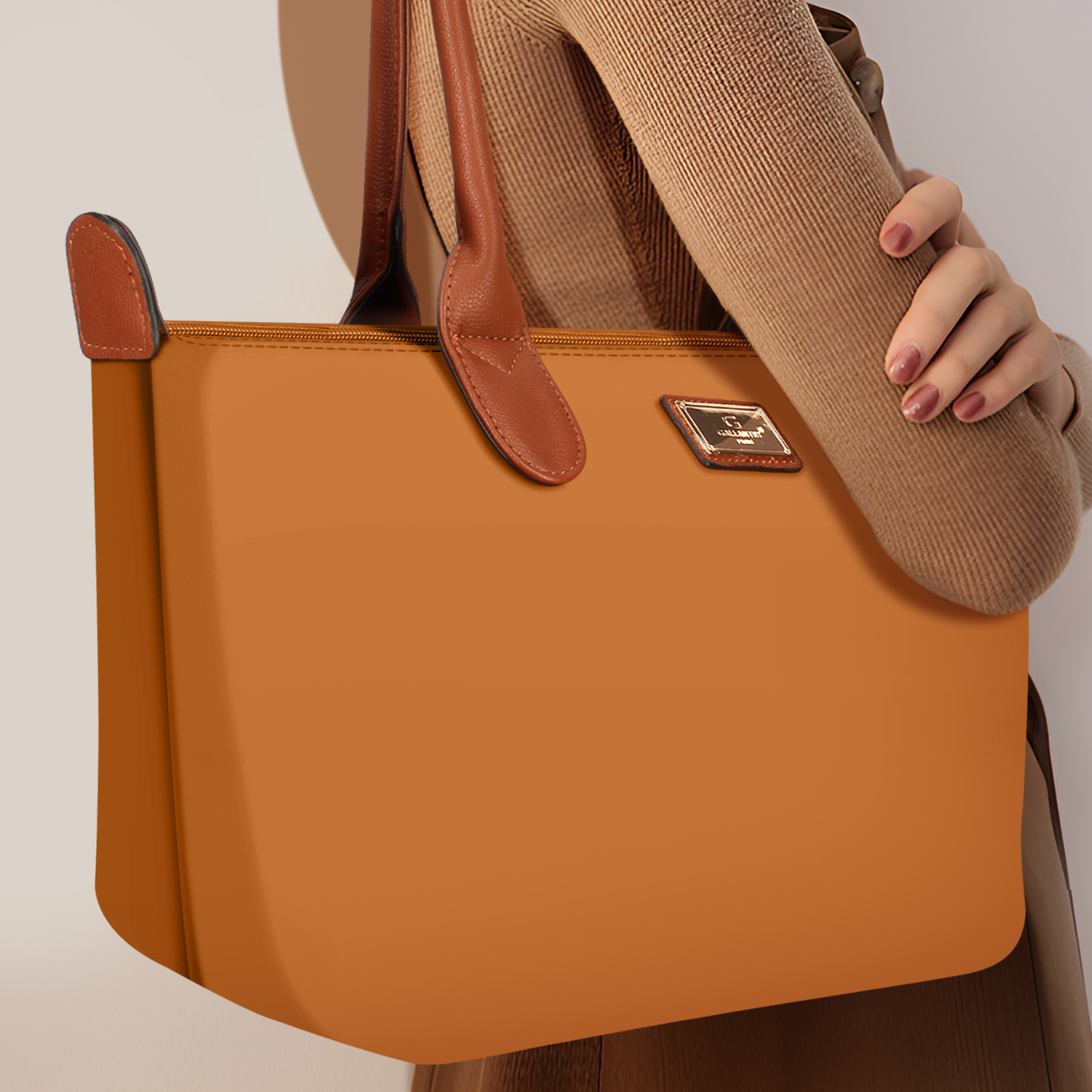 Frau hält eine braune Tragetasche. Die Tasche hat braune Griffe und einen Reißverschluss.