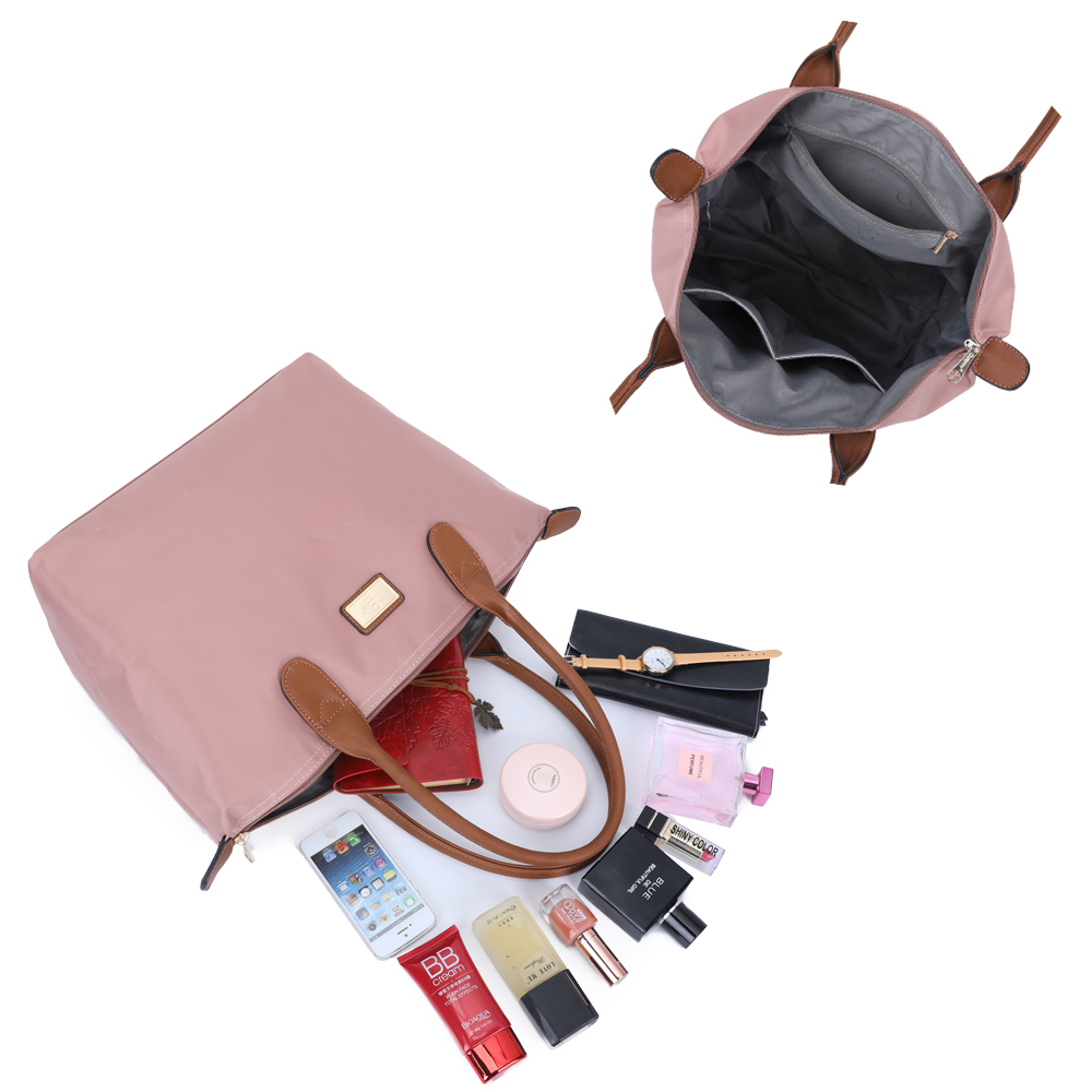 Eine rosa Tasche mit braunen Griffen ist geöffnet. Inhalt: Make-up, Geldbörse, Telefon und Parfüm.