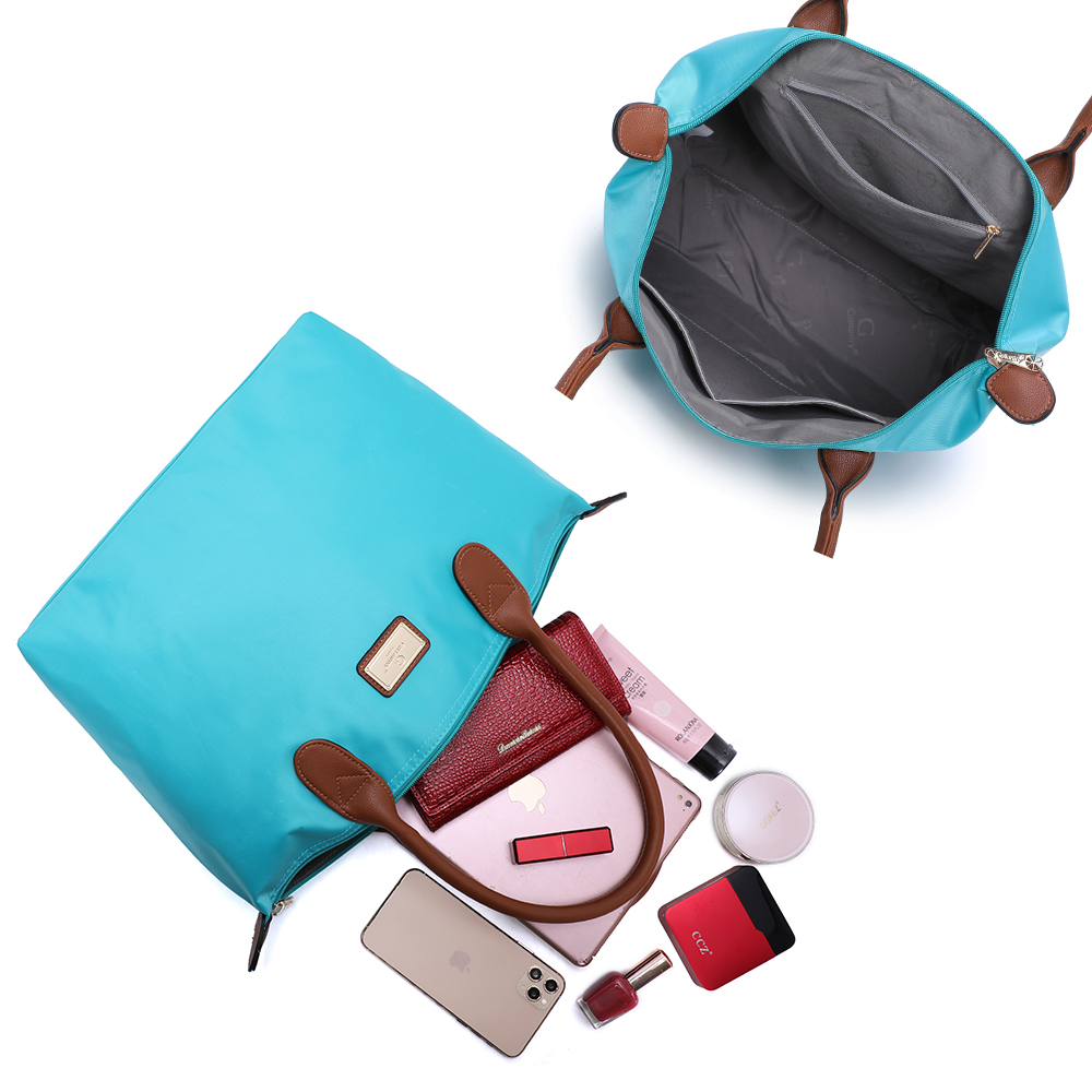 Zwei offene türkisfarbene Taschen, mit Inhalt: Make-up, Telefon, Geldbörse usw. Weißer Hintergrund.