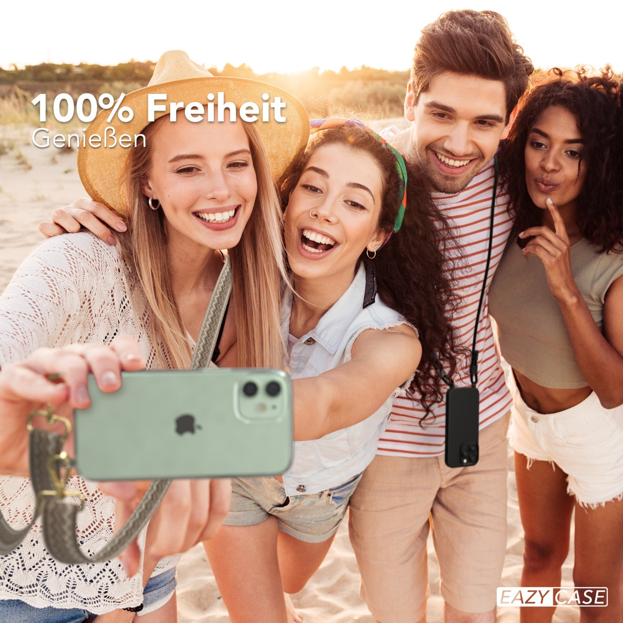 Vier Freunde machen Selfie am Strand. Einer hält Telefon mit Band. Sonne und Sand im Hintergrund.