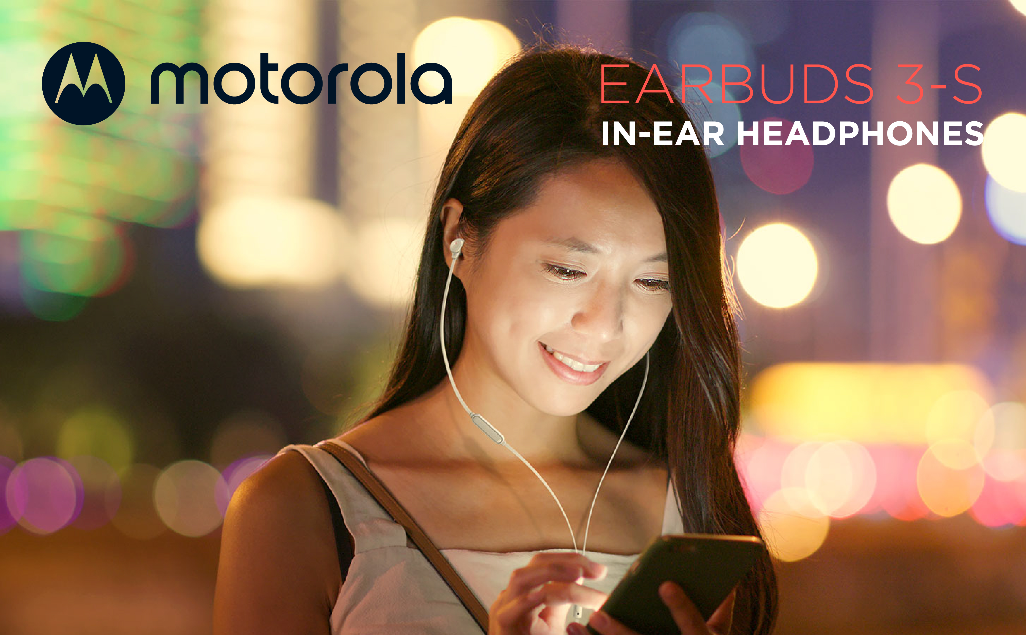 Frau mit Ohrhörern, die auf ihr Telefon schaut. Motorola-Logo sichtbar. Hintergrund mit verschwommenen Lichtern.