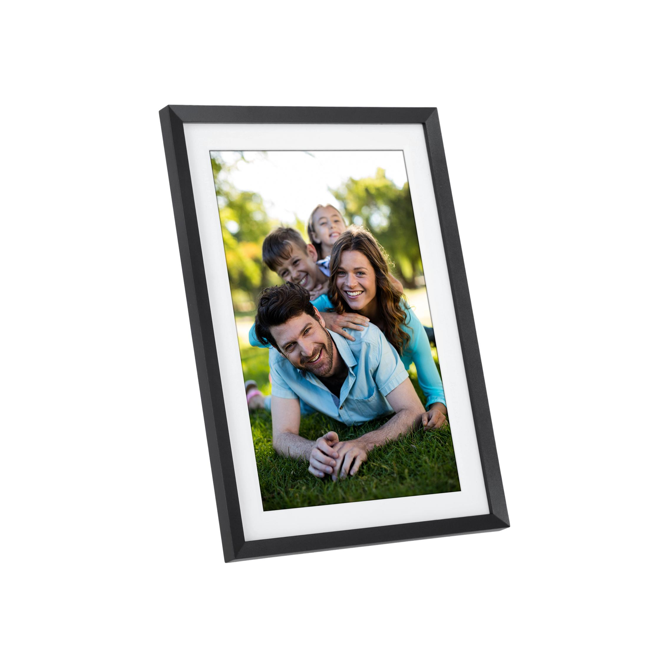 Eine Familie liegt auf dem Rasen und lächelt in die Kamera. Ein schwarzer Rahmen umgibt das Bild.