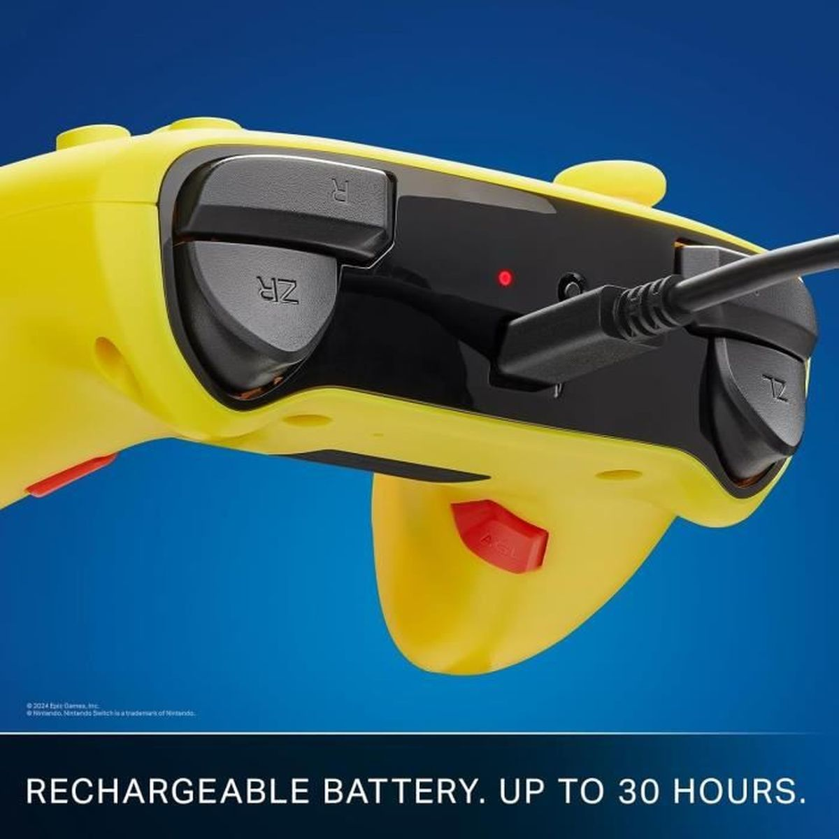 Żółty kontroler do gier z czarnymi przyciskami i czarnym kablem. Niebieskie tło.