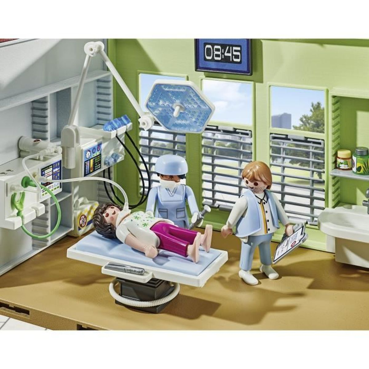 Scena dell'ospedale Playmobil. Un paziente giace su un letto, con un medico e un'infermiera che lo assistono. Luce chirurgica accesa.