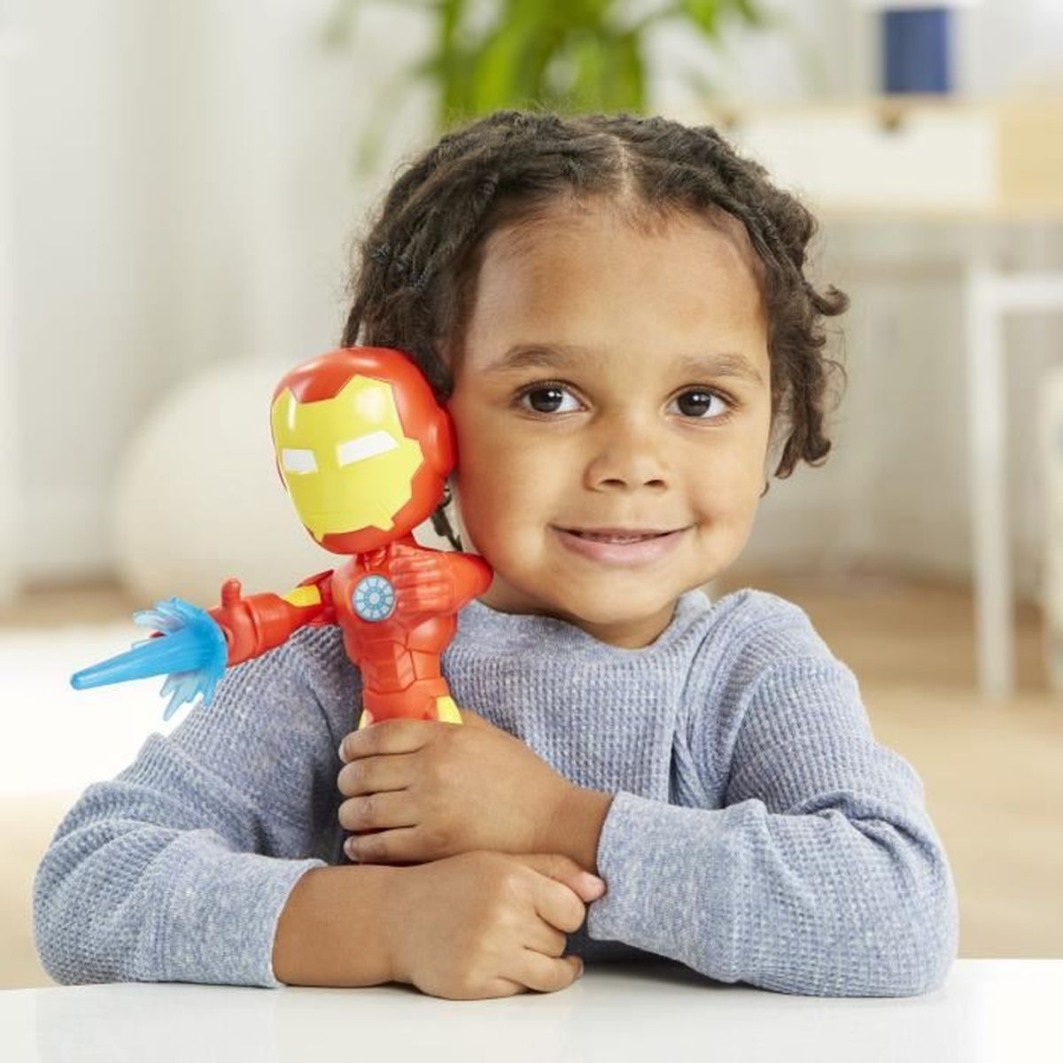 Dziecko trzymające zabawkę Iron Mana z niebieskim pociskiem.